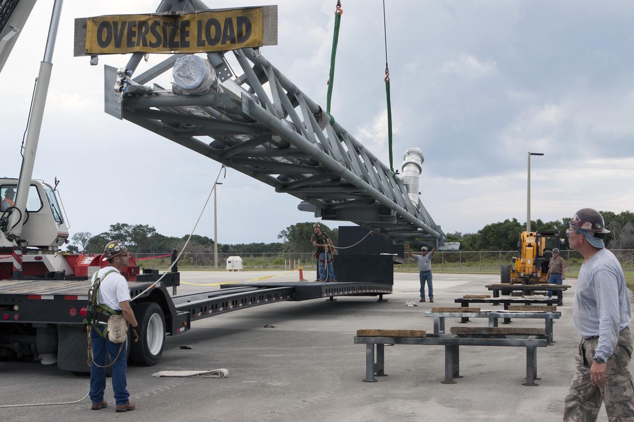 CAPE CANAVERAL, Fla. – The umbilical swing arm for Exploration Flight Test 1, or EFT-1, arrives at the Horizontal Integration Facility near Space Launch Complex 37 at Cape Canaveral Air Force Station in Florida and is being lifted by crane from its transporter. The swing arm is the uppermost of three swing arms that will be attached to the fixed umbilical tower on the launch pad.    The swing arm will carry umbilicals that will be mated to Orion's launch abort system and environmental control system. During launch, the umbilicals will pull away from Orion and the United Launch Alliance Delta IV Heavy rocket at T-0. During the EFT-1 mission, Orion will travel farther into space than any human spacecraft has gone in more than 40 years.  The data gathered during the flight will influence design decisions, validate existing computer models and innovative new approaches to space systems development, as well as reduce overall mission risks and costs for later Orion flights. Liftoff of Orion on its first flight test is planned for fall 2014. Photo credit: NASA/Kim Shiflett
