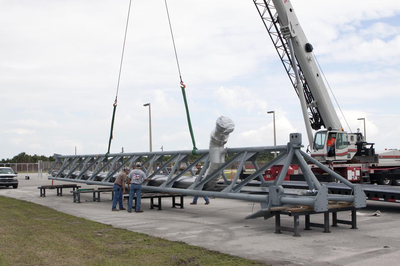 CAPE CANAVERAL, Fla. – The umbilical swing arm for Exploration Flight Test 1, or EFT-1, arrives at the Horizontal Integration Facility near Space Launch Complex 37 at Cape Canaveral Air Force Station in Florida and has been lifted by crane from its transporter. The swing arm is the uppermost of three swing arms that will be attached to the fixed umbilical tower on the launch pad.    The swing arm will carry umbilicals that will be mated to Orion's launch abort system and environmental control system. During launch, the umbilicals will pull away from Orion and the United Launch Alliance Delta IV Heavy rocket at T-0. During the EFT-1 mission, Orion will travel farther into space than any human spacecraft has gone in more than 40 years.  The data gathered during the flight will influence design decisions, validate existing computer models and innovative new approaches to space systems development, as well as reduce overall mission risks and costs for later Orion flights. Liftoff of Orion on its first flight test is planned for fall 2014. Photo credit: NASA/Kim Shiflett