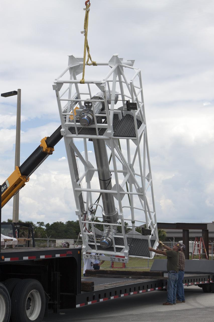 CAPE CANAVERAL, Fla. – Part of the umbilical swing arm for Exploration Flight Test 1, or EFT-1, arrives at the Horizontal Integration Facility near Space Launch Complex 37 at Cape Canaveral Air Force Station in Florida and is being lifted by crane from its transporter. The swing arm is the uppermost of three swing arms that will be attached to the fixed umbilical tower on the launch pad.    The swing arm will carry umbilicals that will be mated to Orion's launch abort system and environmental control system. During launch, the umbilicals will pull away from Orion and the United Launch Alliance Delta IV Heavy rocket at T-0. During the EFT-1 mission, Orion will travel farther into space than any human spacecraft has gone in more than 40 years.  The data gathered during the flight will influence design decisions, validate existing computer models and innovative new approaches to space systems development, as well as reduce overall mission risks and costs for later Orion flights. Liftoff of Orion on its first flight test is planned for fall 2014. Photo credit: NASA/Kim Shiflett