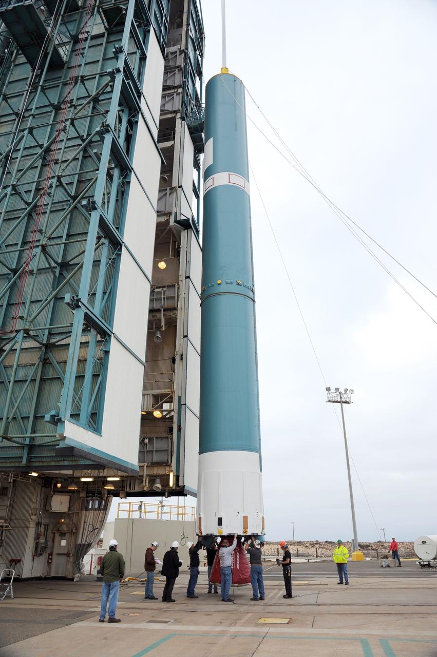 VANDENBERG AIR FORCE BASE, Calif. – Workers steady the first stage of the United Launch Alliance Delta II rocket for NASA's Soil Moisture Active Passive mission, or SMAP, after it is lifted into a vertical position alongside the mobile service tower at Space Launch Complex 2 on Vandenberg Air Force Base in California. SMAP will provide global measurements of soil moisture and its freeze/thaw state. These measurements will be used to enhance understanding of processes that link the water, energy and carbon cycles, and to extend the capabilities of weather and climate prediction models. SMAP data also will be used to quantify net carbon flux in boreal landscapes and to develop improved flood prediction and drought monitoring capabilities. Launch is scheduled for November 2014. To learn more about SMAP, visit http://smap.jpl.nasa.gov. Photo credit: NASA/Tony Vauccin, USAF