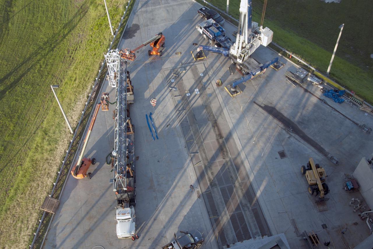 CAPE CANAVERAL, Fla. – In this view from above at Space Launch Complex 37 at Cape Canaveral Air Force Station in Florida, the umbilical swing arm for Exploration Flight Test 1, or EFT-1, is being prepared to be lifted by crane and attached to the fixed umbilical tower on the launch pad. The swing arm is the uppermost of three swing arms that will be attached to the fixed umbilical tower.       The swing arm will carry umbilicals that will be mated to Orion's launch abort system and environmental control system. During launch, the umbilicals will pull away from Orion and the United Launch Alliance Delta IV Heavy rocket at T-0. During the EFT-1 mission, Orion will travel farther into space than any human spacecraft has gone in more than 40 years.  The data gathered during the flight will influence design decisions, validate existing computer models and innovative new approaches to space systems development, as well as reduce overall mission risks and costs for later Orion flights. Liftoff of Orion on its first flight test is planned for fall 2014. Photo credit: NASA/Jim Grossmann