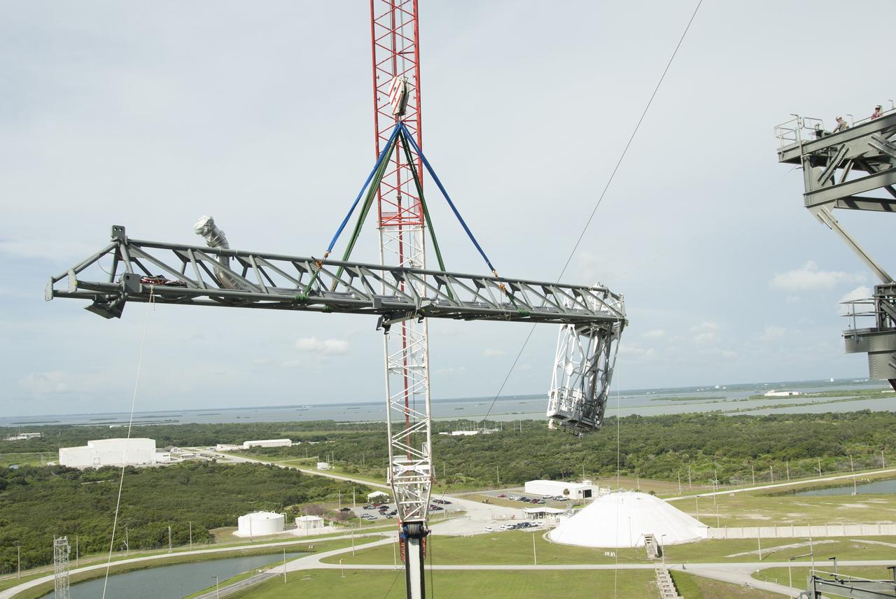 CAPE CANAVERAL, Fla. – The umbilical swing arm for Exploration Flight Test 1, or EFT-1, is lifted high by crane for installation on the fixed umbilical tower at Space Launch Complex 37 at Cape Canaveral Air Force Station in Florida. The swing arm is the uppermost of three swing arms that will be attached to the fixed umbilical tower.    The swing arm will carry umbilicals that will be mated to Orion's launch abort system and environmental control system. During launch, the umbilicals will pull away from Orion and the United Launch Alliance Delta IV Heavy rocket at T-0. During the EFT-1 mission, Orion will travel farther into space than any human spacecraft has gone in more than 40 years.  The data gathered during the flight will influence design decisions, validate existing computer models and innovative new approaches to space systems development, as well as reduce overall mission risks and costs for later Orion flights. Liftoff of Orion on its first flight test is planned for fall 2014. Photo credit: NASA/Jim Grossmann