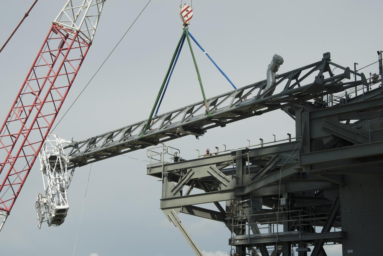 CAPE CANAVERAL, Fla. – A crane brings the umbilical swing arm for Exploration Flight Test 1, or EFT-1, closer for installation on the fixed umbilical tower at Space Launch Complex 37 at Cape Canaveral Air Force Station in Florida. The swing arm is the uppermost of three swing arms that will be attached to the fixed umbilical tower.    The swing arm will carry umbilicals that will be mated to Orion's launch abort system and environmental control system. During launch, the umbilicals will pull away from Orion and the United Launch Alliance Delta IV Heavy rocket at T-0. During the EFT-1 mission, Orion will travel farther into space than any human spacecraft has gone in more than 40 years.  The data gathered during the flight will influence design decisions, validate existing computer models and innovative new approaches to space systems development, as well as reduce overall mission risks and costs for later Orion flights. Liftoff of Orion on its first flight test is planned for fall 2014. Photo credit: NASA/Jim Grossmann