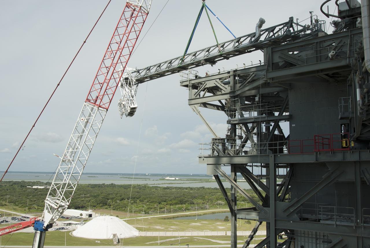 CAPE CANAVERAL, Fla. – A crane brings the umbilical swing arm for Exploration Flight Test 1, or EFT-1, closer for installation on the fixed umbilical tower at Space Launch Complex 37 at Cape Canaveral Air Force Station in Florida. The swing arm is the uppermost of three swing arms that will be attached to the fixed umbilical tower. The swing arm will carry umbilicals that will be mated to Orion's launch abort system and environmental control system. During launch, the umbilicals will pull away from Orion and the United Launch Alliance Delta IV Heavy rocket at T-0. During the EFT-1 mission, Orion will travel farther into space than any human spacecraft has gone in more than 40 years. The data gathered during the flight will influence design decisions, validate existing computer models and innovative new approaches to space systems development, as well as reduce overall mission risks and costs for later Orion flights. Liftoff of Orion on its first flight test is planned for fall 2014. Photo credit: NASA/Jim Grossmann
