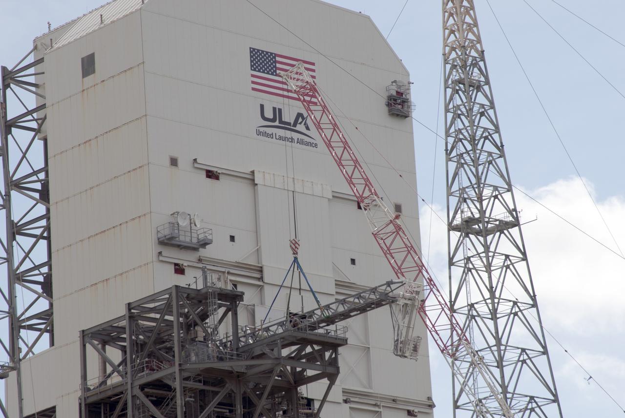 CAPE CANAVERAL, Fla. – A crane brings the umbilical swing arm for Exploration Flight Test 1, or EFT-1, closer for installation on the fixed umbilical tower at Space Launch Complex 37 at Cape Canaveral Air Force Station in Florida. The swing arm is the uppermost of three swing arms that will be attached to the fixed umbilical tower.    The swing arm will carry umbilicals that will be mated to Orion's launch abort system and environmental control system. During launch, the umbilicals will pull away from Orion and the United Launch Alliance Delta IV Heavy rocket at T-0. During the EFT-1 mission, Orion will travel farther into space than any human spacecraft has gone in more than 40 years.  The data gathered during the flight will influence design decisions, validate existing computer models and innovative new approaches to space systems development, as well as reduce overall mission risks and costs for later Orion flights. Liftoff of Orion on its first flight test is planned for fall 2014. Photo credit: NASA/Jim Grossmann
