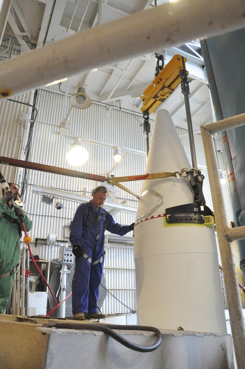 VANDENBERG AIR FORCE BASE, Calif. – Workers in the mobile service tower at Space Launch Complex 2 on Vandenberg Air Force Base in California monitor a solid rocket motor as it is installed on the Delta II rocket for NASA's Soil Moisture Active Passive mission, or SMAP.    SMAP will be launched on a Delta II 7320 configuration vehicle featuring a United Launch Alliance first stage booster powered by an Aerojet Rocketdyne RS-27A main engine and three Alliant Techsystems, or ATK, strap-on solid rocket motors. Once on station in Earth orbit, SMAP will provide global measurements of soil moisture and its freeze/thaw state. These measurements will be used to enhance understanding of processes that link the water, energy and carbon cycles, and to extend the capabilities of weather and climate prediction models. SMAP data also will be used to quantify net carbon flux in boreal landscapes and to develop improved flood prediction and drought monitoring capabilities. Launch is scheduled for no earlier than November 2014. To learn more about SMAP, visit http://smap.jpl.nasa.gov.  Photo credit: NASA/Randy Beaudoin