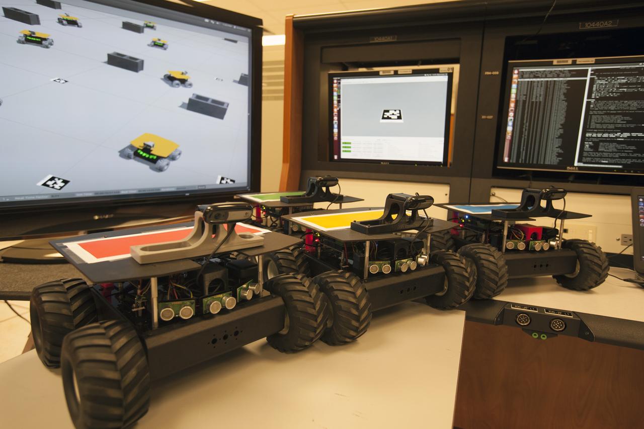 CAPE CANAVERAL, Fla. – The four "Swarmies" robots on a table with the software simulation used to develop the program to control the robots. Photo credit: NASA/Dmitri Gerondidakis