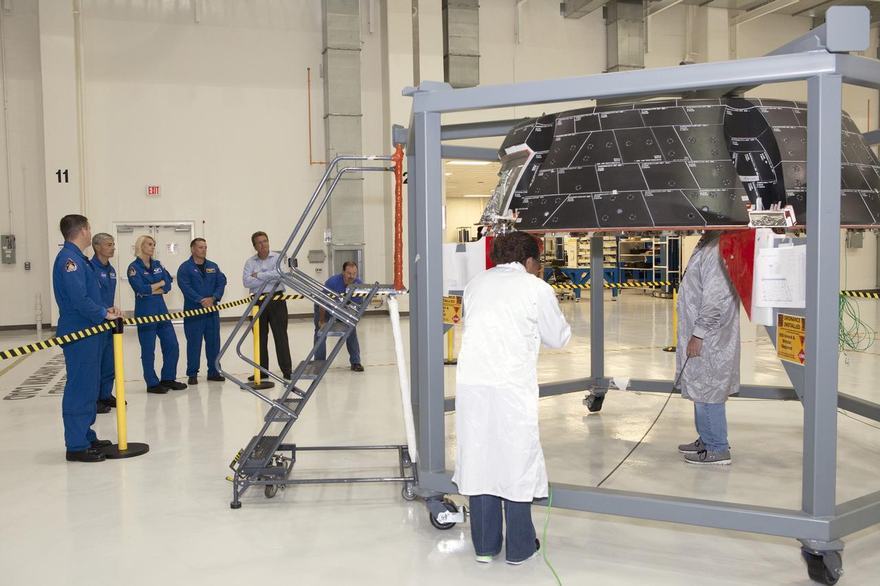 CAPE CANAVERAL, Fla. – NASA astronauts tour the Neil Armstrong Operations and Checkout Building high bay at NASA's Kennedy Space Center in Florida, and view the Orion forward bay cover for Exploration Flight Test-1. From left, are Jack Fischer, Mark Vande Hei, Katie Rubins and Scott Tingle. Orion is the exploration spacecraft designed to carry astronauts to destinations not yet explored by humans, including an asteroid and Mars. It will have emergency abort capability, sustain the crew during space travel and provide safe re-entry from deep space return velocities. The first unpiloted test flight of Orion is scheduled to launch in 2014 atop a United Launch Alliance Delta IV rocket and in 2018 on NASA’s Space Launch System rocket. For more information, visit www.nasa.gov/orion. Photo credit: Dimitri Gerondidakis