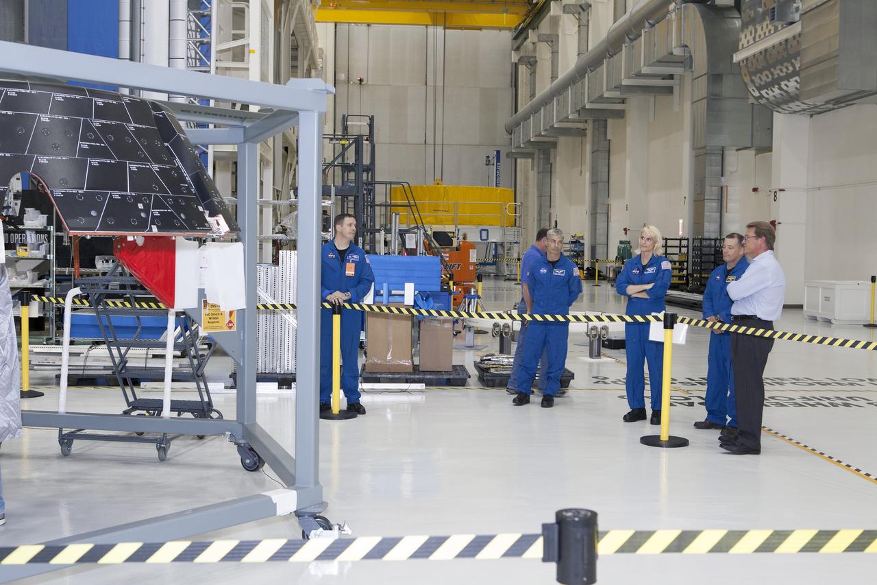 CAPE CANAVERAL, Fla. – NASA astronauts tour the Neil Armstrong Operations and Checkout Building high bay at NASA's Kennedy Space Center in Florida, and view the Orion forward bay cover for Exploration Flight Test-1. From left, are Jack Fischer, Mark Vande Hei, Katie Rubins and Scott Tingle. At far right is Jules Schneider, Lockheed Martin senior manager. Orion is the exploration spacecraft designed to carry astronauts to destinations not yet explored by humans, including an asteroid and Mars. It will have emergency abort capability, sustain the crew during space travel and provide safe re-entry from deep space return velocities. The first unpiloted test flight of Orion is scheduled to launch in 2014 atop a United Launch Alliance Delta IV rocket and in 2018 on NASA’s Space Launch System rocket. For more information, visit www.nasa.gov/orion. Photo credit: Dimitri Gerondidakis