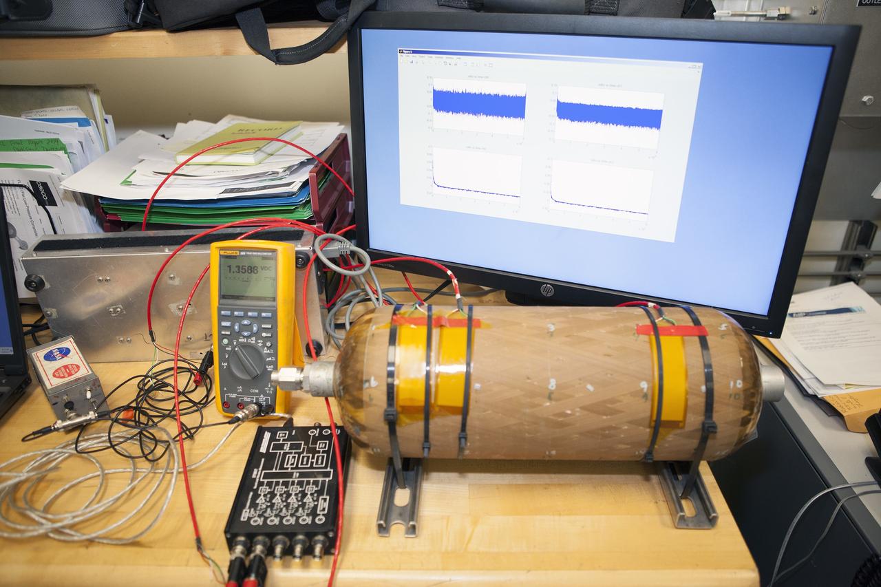 CAPE CANAVERAL, Fla. – Several Lead Zirconate Titanate, or PZT, mass gaging sensors have been attached to a composite tank during a test inside a laboratory at the Cryogenics Testbed Facility at NASA's Kennedy Space Center in Florida. The PZT-based system was developed at Kennedy as a way to measure the mass of a fluid and the structural health of a tank using vibration signatures on Earth or in reduced/zero g gravity.    The mass gaging technology has received approval to be on the first sub-orbital flight on the Virgin Galactic Space Plane in 2015. NASA experiments using the PZT technology will be used by Embry-Riddle Aeronautical University in conjunction with Carthage College on a fluid transfer experiment. Photo credit: NASA/Daniel Casper