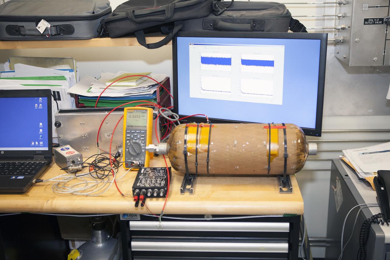 CAPE CANAVERAL, Fla. – Several Lead Zirconate Titanate, or PZT, mass gaging sensors have been attached to a composite tank during a test inside a laboratory at the Cryogenics Testbed Facility at NASA's Kennedy Space Center in Florida. The PZT-based system was developed at Kennedy as a way to measure the mass of a fluid and the structural health of a tank using vibration signatures on Earth or in reduced/zero g gravity.    The mass gaging technology has received approval to be on the first sub-orbital flight on the Virgin Galactic Space Plane in 2015. NASA experiments using the PZT technology will be used by Embry-Riddle Aeronautical University in conjunction with Carthage College on a fluid transfer experiment. Photo credit: NASA/Daniel Casper