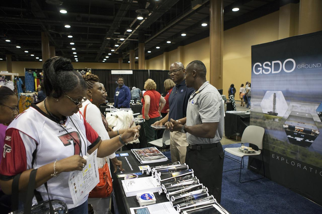KISSIMMEE, Fla. – During the Tom Joyner Family Reunion, Ken Fullwood of Booz-Allen-Hamilton, left, and Yves Lamothe of the NASA Technical Management Branch of the Ground Systems Development and Operations Program talk to guests about ongoing work to convert the Kennedy Space Center into a 21st century spaceport.      The Tom Joyner Family Reunion is designed to present uplifting programs, entertainment and information about growing, diverse communities. An annual event of the nationally-syndicated Tom Joyner Morning Show, the many exhibits included NASA's participation focusing on encouraging young people to consider studies and careers in STEM -- science, technology, engineering and math. NASA's Education Division promoted the benefits of math and scientific learning along with career opportunities offered by the space agency. The activities took place at the Gaylord Palms Resort in Kissimmee, Florida, during the Labor Day weekend. Photo credit: NASA/Daniel Casper