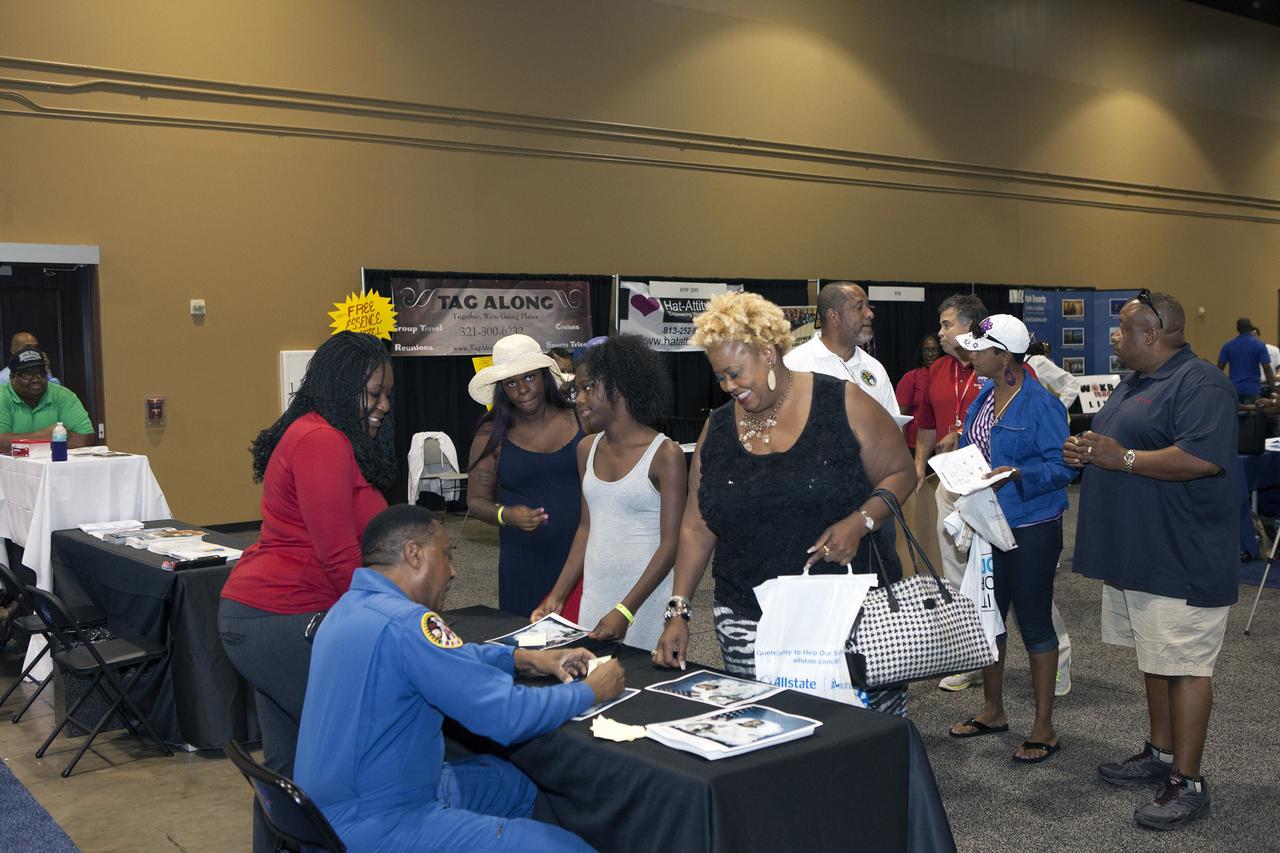 KISSIMMEE, Fla. – Former NASA astronaut Winston Scott signed autographs and posed for pictures with guests at the agency exhibit during the Tom Joyner Family Reunion. Now a senior vice president at the Florida Institute of Technology, he said that he likes to emphasize to young people how important a good education is in preparation for the future.      The Tom Joyner Family Reunion is designed to present uplifting programs, entertainment and information about growing, diverse communities. An annual event of the nationally-syndicated Tom Joyner Morning Show, the many exhibits included NASA's participation focusing on encouraging young people to consider studies and careers in STEM -- science, technology, engineering and math. NASA's Education Division promoted the benefits of math and scientific learning along with career opportunities offered by the space agency. The activities took place at the Gaylord Palms Resort in Kissimmee, Florida, during the Labor Day weekend. Photo credit: NASA/Daniel Casper