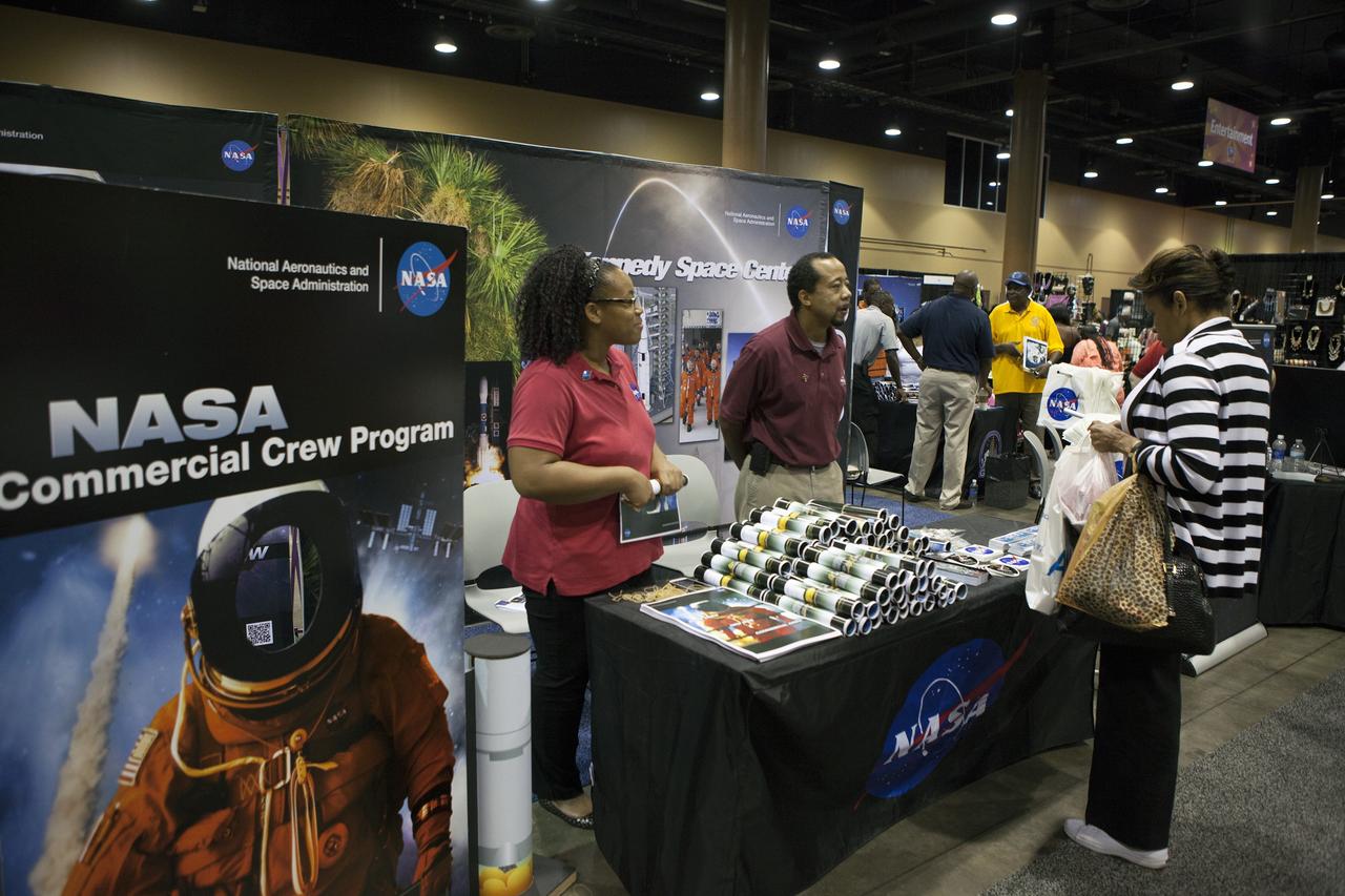 KISSIMMEE, Fla. – A guest at the Tom Joyner Family Reunion talks with Brittani Sims, left, and Sheldon Lauderdale, both work in the Program Control and Integration Office of the Commercial Crew Program. They explained that the program is facilitating development of American commercial crew space transportation capability to achieve safe, reliable and cost-effective access to and from the International Space Station and low-Earth orbit.      The Tom Joyner Family Reunion is designed to present uplifting programs, entertainment and information about growing, diverse communities. An annual event of the nationally-syndicated Tom Joyner Morning Show, the many exhibits included NASA's participation focusing on encouraging young people to consider studies and careers in STEM -- science, technology, engineering and math. NASA's Education Division promoted the benefits of math and scientific learning along with career opportunities offered by the space agency. The activities took place at the Gaylord Palms Resort in Kissimmee, Florida, during the Labor Day weekend. Photo credit: NASA/Daniel Casper