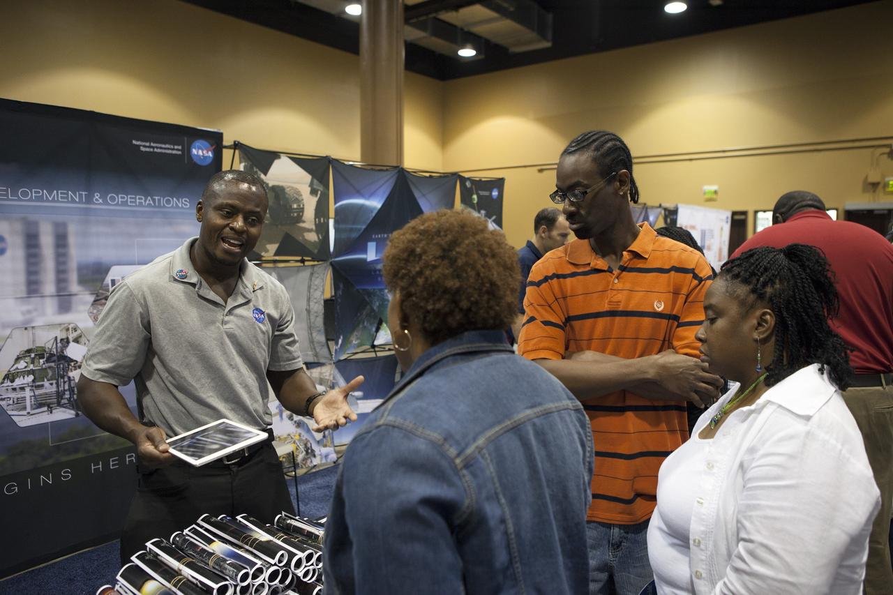 KISSIMMEE, Fla. – Yves Lamothe of the NASA Technical Management Branch of Ground Systems Development and Operations Program speaks with guests at the Tom Joyner Family Reunion about ongoing work to convert the Kennedy Space Center into a 21st century spaceport.      The Tom Joyner Family Reunion is designed to present uplifting programs, entertainment and information about growing, diverse communities. An annual event of the nationally-syndicated Tom Joyner Morning Show, the many exhibits included NASA's participation focusing on encouraging young people to consider studies and careers in STEM -- science, technology, engineering and math. NASA's Education Division promoted the benefits of math and scientific learning along with career opportunities offered by the space agency. The activities took place at the Gaylord Palms Resort in Kissimmee, Florida, during the Labor Day weekend. Photo credit: NASA/Daniel Casper