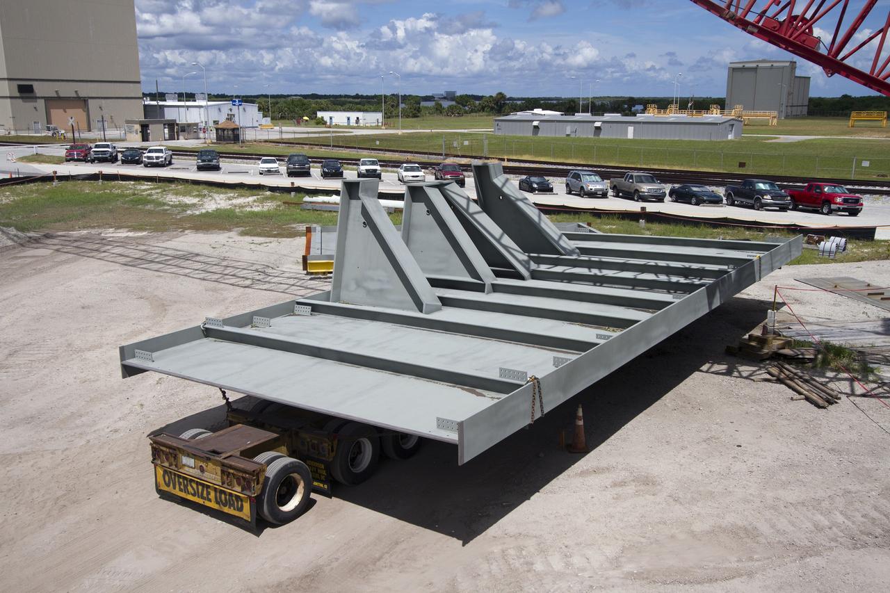 CAPE CANAVERAL, Fla. – Modifications continue on the Mobile Launcher, or ML, at the Mobile Launcher Park Site at NASA’s Kennedy Space Center in Florida. A new steel beam has arrived for installation on the ML structure. The ML is being modified and strengthened to accommodate the weight, size and thrust at launch of NASA's Space Launch System, or SLS, and Orion spacecraft.    In 2013, the agency awarded a contract to J.P. Donovan Construction Inc. of Rockledge, Fla., to modify the ML, which is one of the key elements of ground support equipment that is being upgraded by the Ground Systems Development and Operations Program at Kennedy. The existing 24-foot exhaust hole is being enlarged and strengthened for the larger, heavier SLS rocket. The ML will carry the SLS rocket and Orion spacecraft to Launch Pad 39B for its first uncrewed mission, Exploration Mission-1, in 2018. Photo credit: NASA/Cory Huston