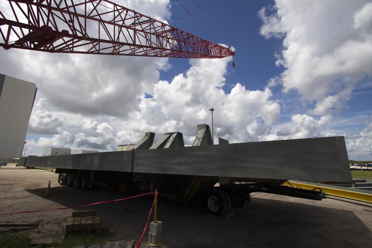 CAPE CANAVERAL, Fla. – Modifications continue on the Mobile Launcher, or ML, at the Mobile Launcher Park Site at NASA’s Kennedy Space Center in Florida. A crane is in place to lift a new steel beam for installation on the ML structure. The ML is being modified and strengthened to accommodate the weight, size and thrust at launch of NASA's Space Launch System, or SLS, and Orion spacecraft.    In 2013, the agency awarded a contract to J.P. Donovan Construction Inc. of Rockledge, Fla., to modify the ML, which is one of the key elements of ground support equipment that is being upgraded by the Ground Systems Development and Operations Program at Kennedy. The existing 24-foot exhaust hole is being enlarged and strengthened for the larger, heavier SLS rocket. The ML will carry the SLS rocket and Orion spacecraft to Launch Pad 39B for its first uncrewed mission, Exploration Mission-1, in 2018. Photo credit: NASA/Cory Huston