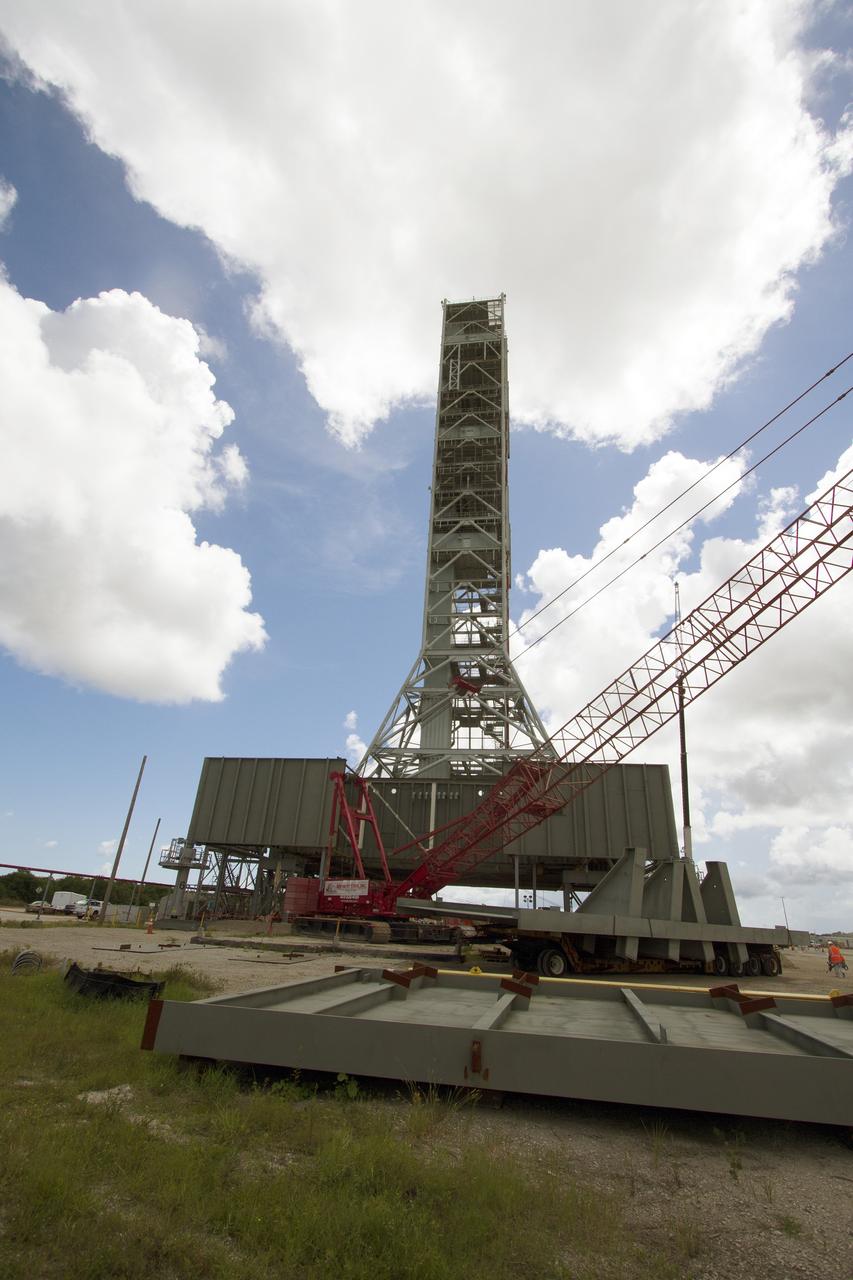CAPE CANAVERAL, Fla. – Modifications continue on the Mobile Launcher, or ML, at the Mobile Launcher Park Site at NASA’s Kennedy Space Center in Florida. A crane is used to lift a new steel beam for installation on the ML structure. The ML is being modified and strengthened to accommodate the weight, size and thrust at launch of NASA's Space Launch System, or SLS, and Orion spacecraft.    In 2013, the agency awarded a contract to J.P. Donovan Construction Inc. of Rockledge, Fla., to modify the ML, which is one of the key elements of ground support equipment that is being upgraded by the Ground Systems Development and Operations Program at Kennedy. The existing 24-foot exhaust hole is being enlarged and strengthened for the larger, heavier SLS rocket. The ML will carry the SLS rocket and Orion spacecraft to Launch Pad 39B for its first uncrewed mission, Exploration Mission-1, in 2018. Photo credit: NASA/Cory Huston