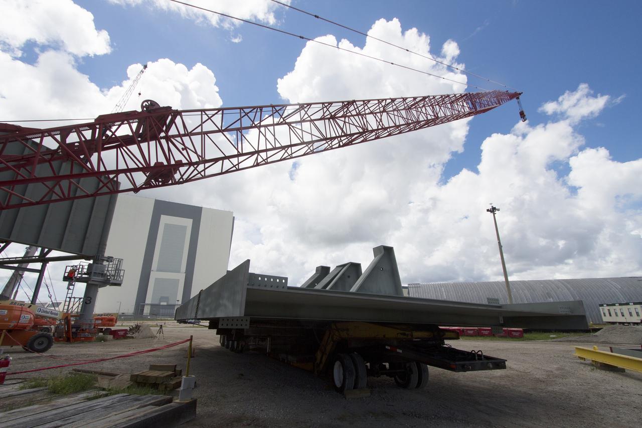 CAPE CANAVERAL, Fla. – Modifications continue on the Mobile Launcher, or ML, at the Mobile Launcher Park Site at NASA’s Kennedy Space Center in Florida. A crane is in place to lift a new steel beam for installation on the ML structure. The ML is being modified and strengthened to accommodate the weight, size and thrust at launch of NASA's Space Launch System, or SLS, and Orion spacecraft.    In 2013, the agency awarded a contract to J.P. Donovan Construction Inc. of Rockledge, Fla., to modify the ML, which is one of the key elements of ground support equipment that is being upgraded by the Ground Systems Development and Operations Program at Kennedy. The existing 24-foot exhaust hole is being enlarged and strengthened for the larger, heavier SLS rocket. The ML will carry the SLS rocket and Orion spacecraft to Launch Pad 39B for its first uncrewed mission, Exploration Mission-1, in 2018. Photo credit: NASA/Cory Huston
