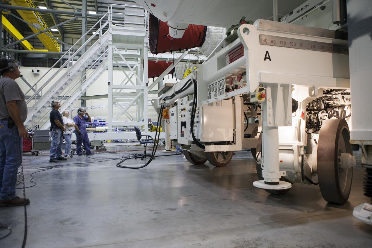 CAPE CANAVERAL, Fla. – United Launch Alliance, or ULA, technicians monitor the progress as the Delta IV port booster is mated to the core booster inside the Horizontal Integration Facility at Space Launch Complex 37 on Cape Canaveral Air Force Station in Florida. The ULA Delta IV Heavy rocket will launch an uncrewed Orion spacecraft on Exploration Flight Test-1. During the mission, Orion will travel farther into space than any human spacecraft has gone in more than 40 years. The data gathered during the flight will influence design decisions, validate existing computer models and innovative new approaches to space systems development, as well as reduce overall mission risks and costs for later Orion flights. Liftoff of Orion on the first flight test is planned for December 2014. Photo credit: NASA/Ben Smegelsky