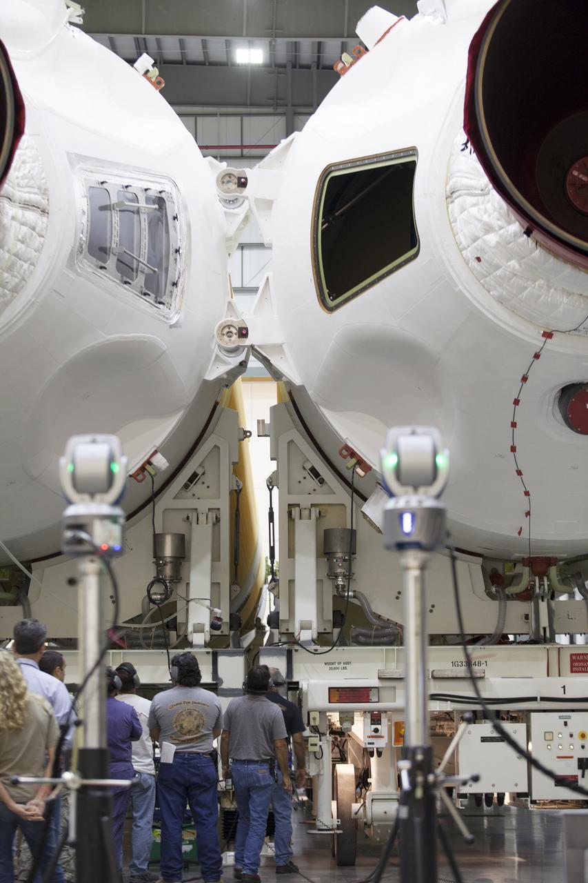 CAPE CANAVERAL, Fla. – United Launch Alliance, or ULA, technicians monitor the progress as the Delta IV port booster is mated to the core booster inside the Horizontal Integration Facility at Space Launch Complex 37 on Cape Canaveral Air Force Station in Florida. The ULA Delta IV Heavy rocket will launch an uncrewed Orion spacecraft on Exploration Flight Test-1. During the mission, Orion will travel farther into space than any human spacecraft has gone in more than 40 years. The data gathered during the flight will influence design decisions, validate existing computer models and innovative new approaches to space systems development, as well as reduce overall mission risks and costs for later Orion flights. Liftoff of Orion on the first flight test is planned for December 2014. Photo credit: NASA/Ben Smegelsky