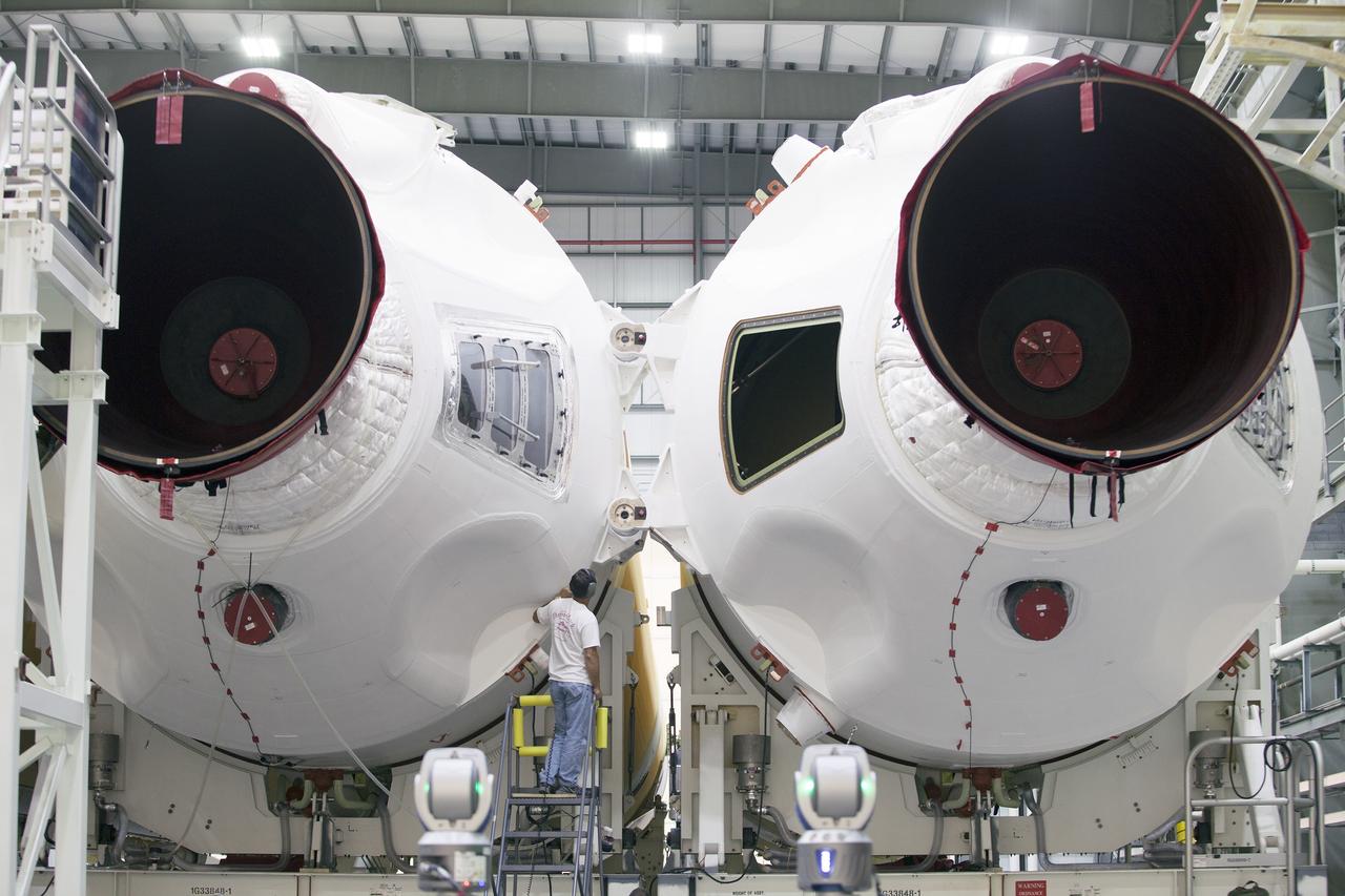 CAPE CANAVERAL, Fla. – A United Launch Alliance, or ULA, technician monitors the progress as the Delta IV port booster is mated to the core booster inside the Horizontal Integration Facility at Space Launch Complex 37 on Cape Canaveral Air Force Station in Florida. The ULA Delta IV Heavy rocket will launch an uncrewed Orion spacecraft on Exploration Flight Test-1. During the mission, Orion will travel farther into space than any human spacecraft has gone in more than 40 years. The data gathered during the flight will influence design decisions, validate existing computer models and innovative new approaches to space systems development, as well as reduce overall mission risks and costs for later Orion flights. Liftoff of Orion on the first flight test is planned for December 2014. Photo credit: NASA/Ben Smegelsky