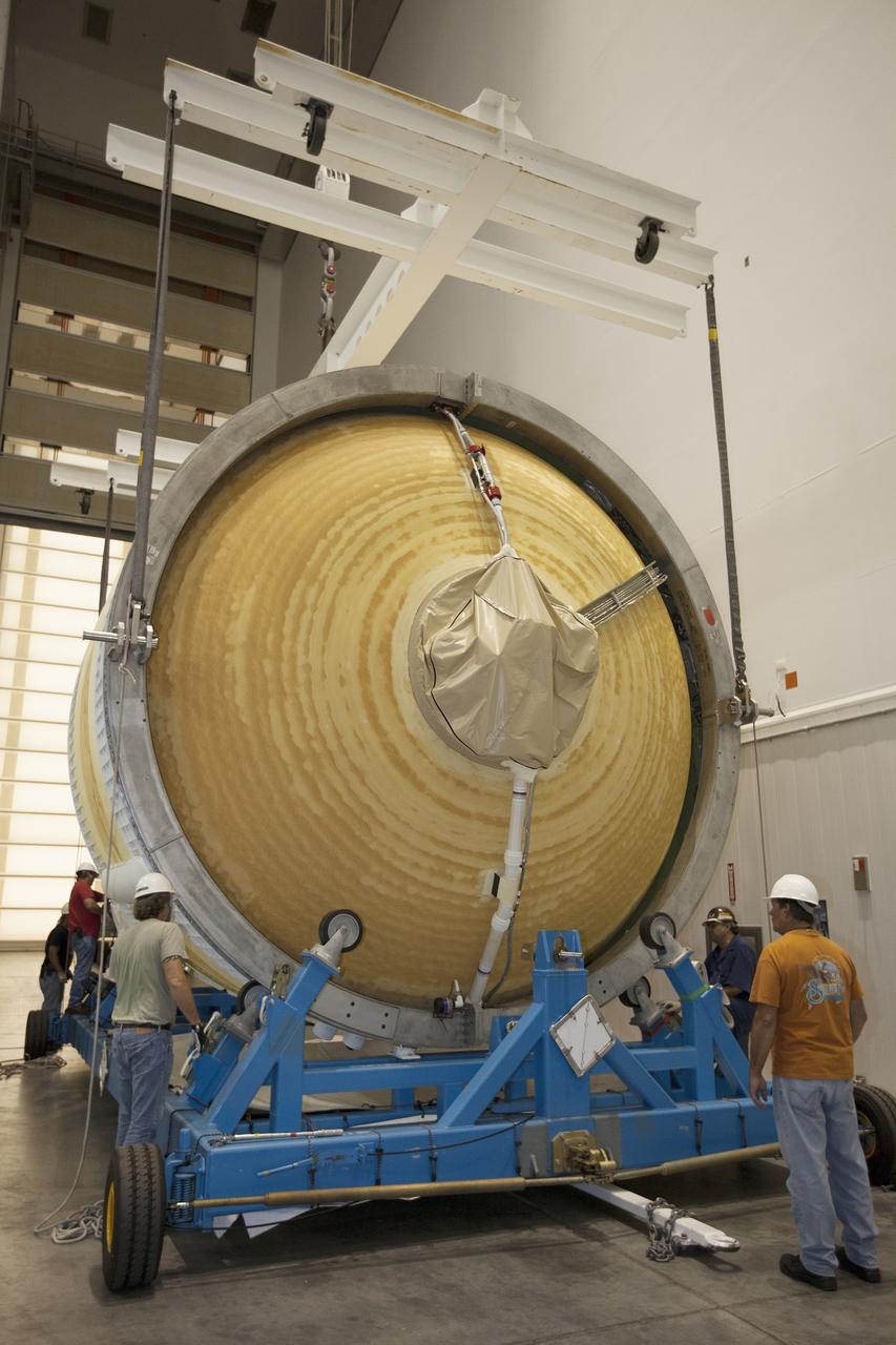 CAPE CANAVERAL, Fla. – Inside the Delta Operations Center at Cape Canaveral Air Force Station, United Launch Alliance technicians place the second stage of a Delta IV Heavy rocket on a transporter following testing in preparation for the unpiloted Exploration Flight Test-1, or EFT-1. The second stage will be moved to the Horizontal Integration Facility at Space Launch Complex 37 for mating with the Delta IV Heavy booster stages. During the mission, Orion will travel farther into space than any human spacecraft has gone in more than 40 years. The data gathered during the flight will influence design decisions, validate existing computer models and innovative new approaches to space systems development, as well as reduce overall mission risks and costs for later Orion flights. Liftoff of Orion on the first flight test is planned for December 2014. Photo credit: NASA/Kim Shiflett
