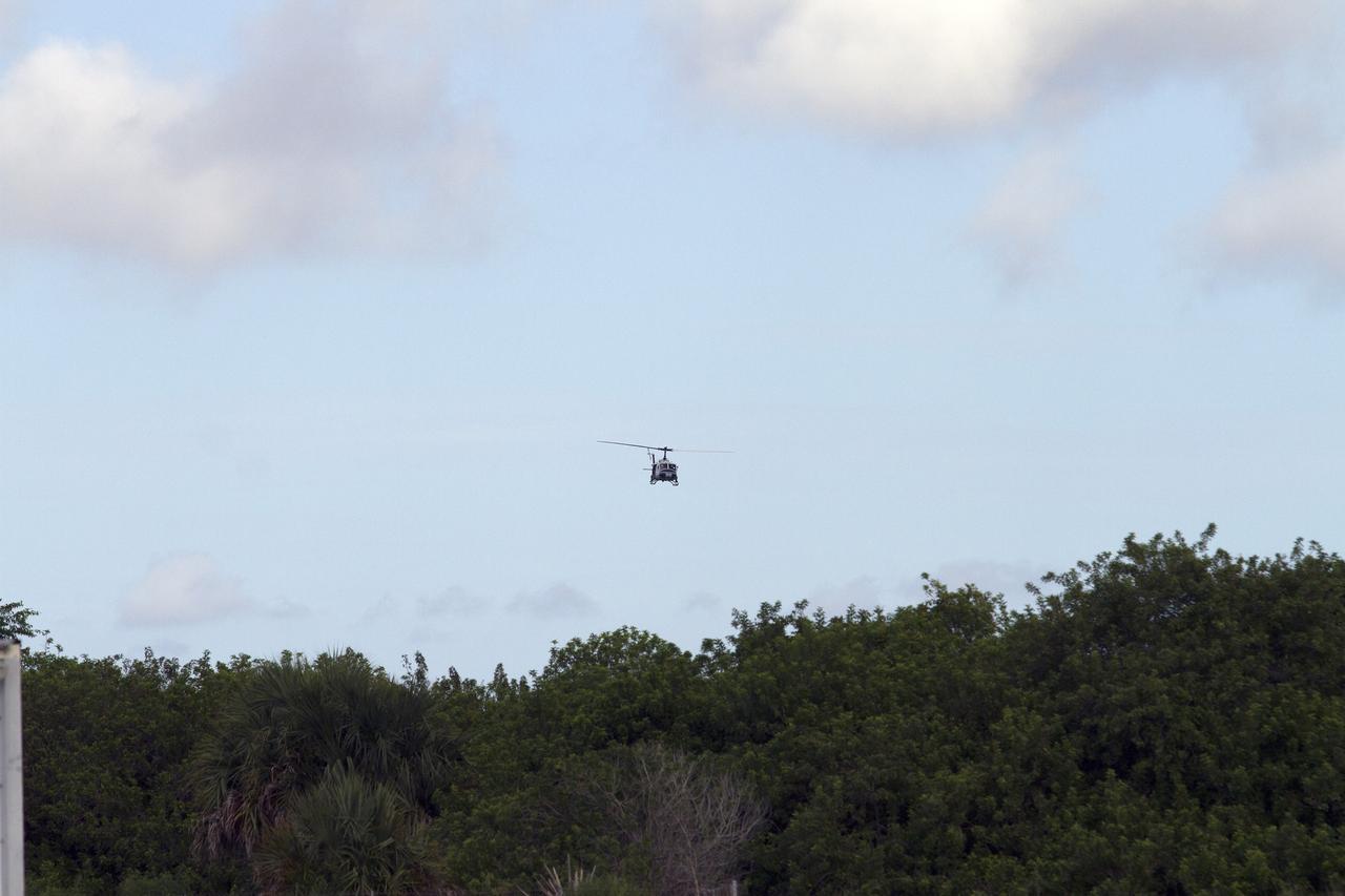 CAPE CANAVERAL, Fla. – A Huey helicopter from the Aircraft Operations branch at NASA's Kennedy Space Center in Florida flies into a training area with a group of Emergency Response Team officers from the center's Protective Services branch. The flight was the beginning of a training mission to simulate a situation the team and pilots could confront at the center. Photo credit: NASA/Dan Casper