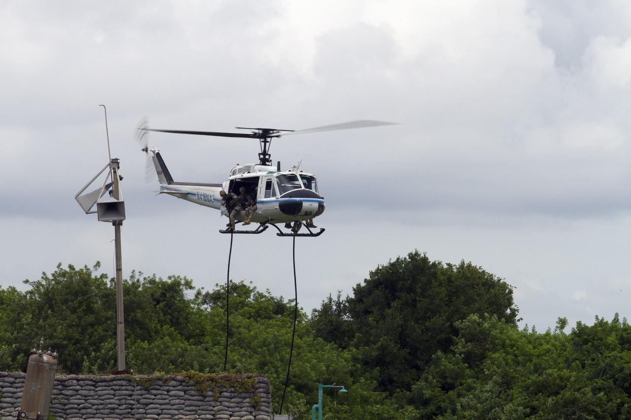 CAPE CANAVERAL, Fla. – Emergency Response Team officers from the Protective Services branch of NASA's Kennedy Space Center in Florida prepare to descend from a Huey helicopter from the Aircraft Operations branch during a training exercise. The flight was the beginning of a training mission to simulate a situation the team and pilots could confront at the center. Photo credit: NASA/Dan Casper