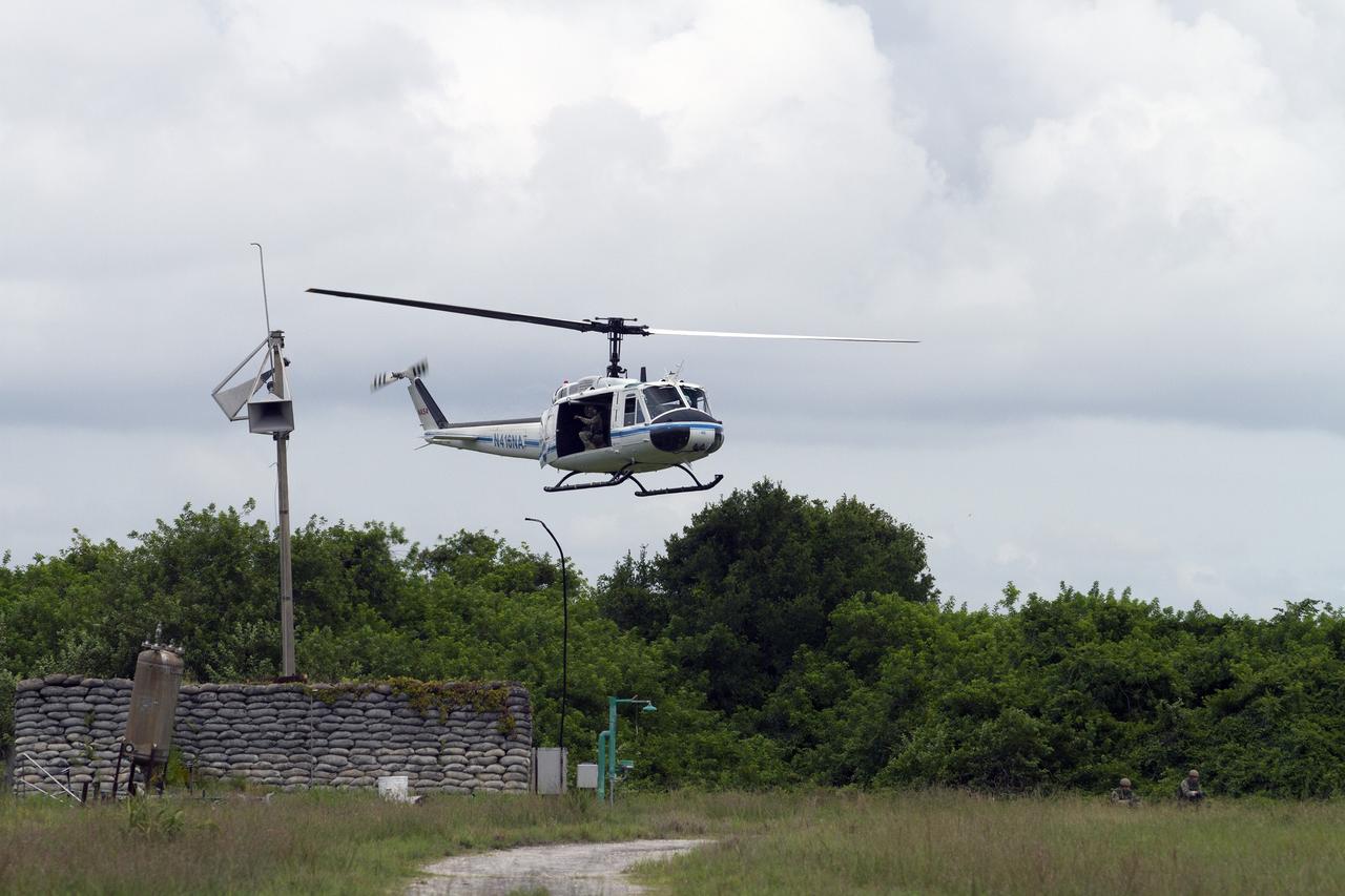 CAPE CANAVERAL, Fla. – The rope is cut from a Huey helicopter from the Aircraft Operations branch at NASA's Kennedy Space Center in Florida before the helicopter begins to fly out of a training area during a training exercise. Moments earlier, Emergency Response Team officers from the Protective Services branch descended from the helicopter to begin the mission. The flight was the beginning of a training mission to simulate a situation the team and pilots could confront at the center. Photo credit: NASA/Dan Casper