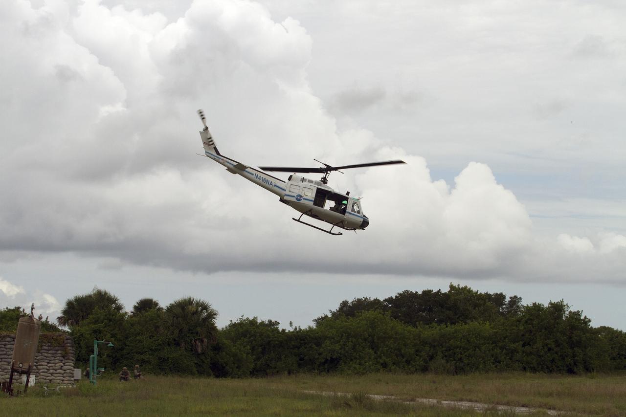 CAPE CANAVERAL, Fla. – A Huey helicopter from the Aircraft Operations branch at NASA's Kennedy Space Center in Florida begins to fly out of a training area after Emergency Response Team officers from the Protective Services branch descended from the helicopter during a training exercise. The flight was the beginning of a training mission to simulate a situation the team and pilots could confront at the center. Photo credit: NASA/Dan Casper