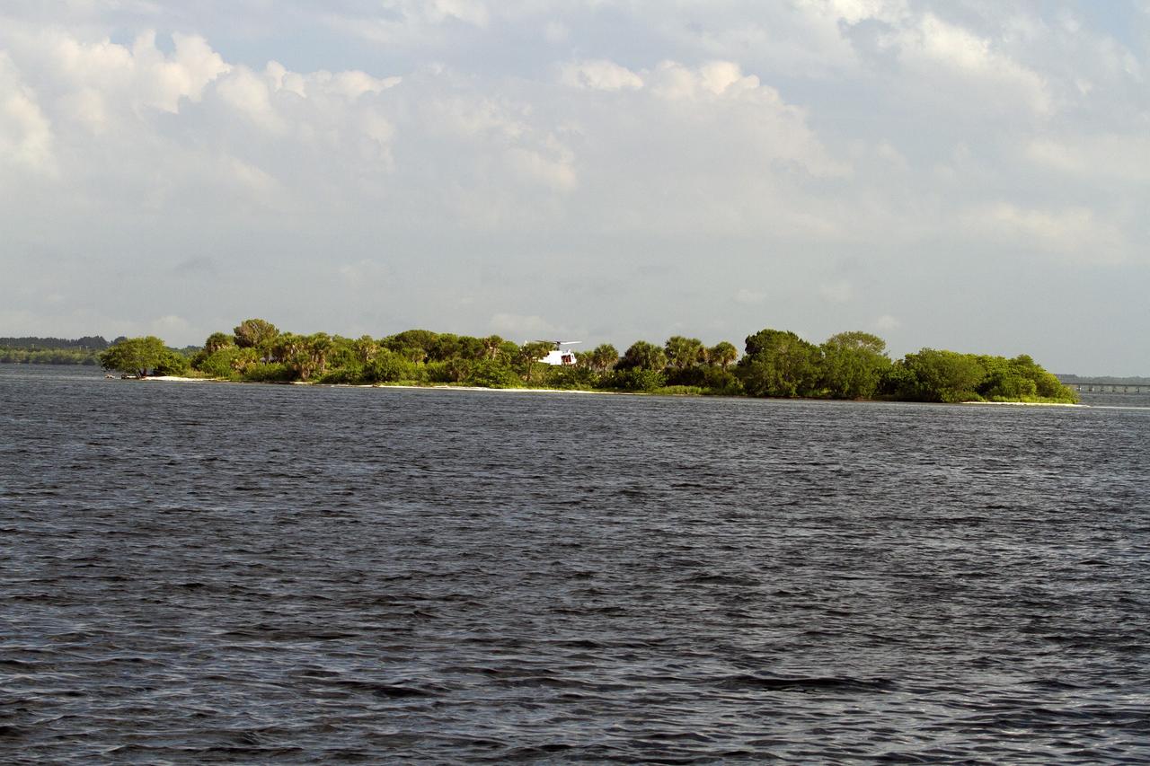 CAPE CANAVERAL, Fla. – A Huey helicopter from the Aircraft Operations branch at NASA's Kennedy Space Center in Florida flies over the Indian River Lagoon with a group of Emergency Response Team officers from the center's Protective Services branch during a training exercise. The training session focused on safely entering the water, something the ERT could be required to perform in certain situations at the center. Photo credit: NASA/ Dan Casper
