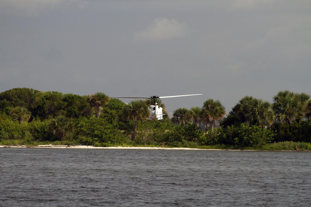 CAPE CANAVERAL, Fla. – A Huey helicopter from the Aircraft Operations branch at NASA's Kennedy Space Center in Florida flies over the Indian River Lagoon with a group of Emergency Response Team officers from the center's Protective Services branch during a training exercise. The training session focused on safely entering the water, something the ERT could be required to perform in certain situations at the center. Photo credit: NASA/ Dan Casper
