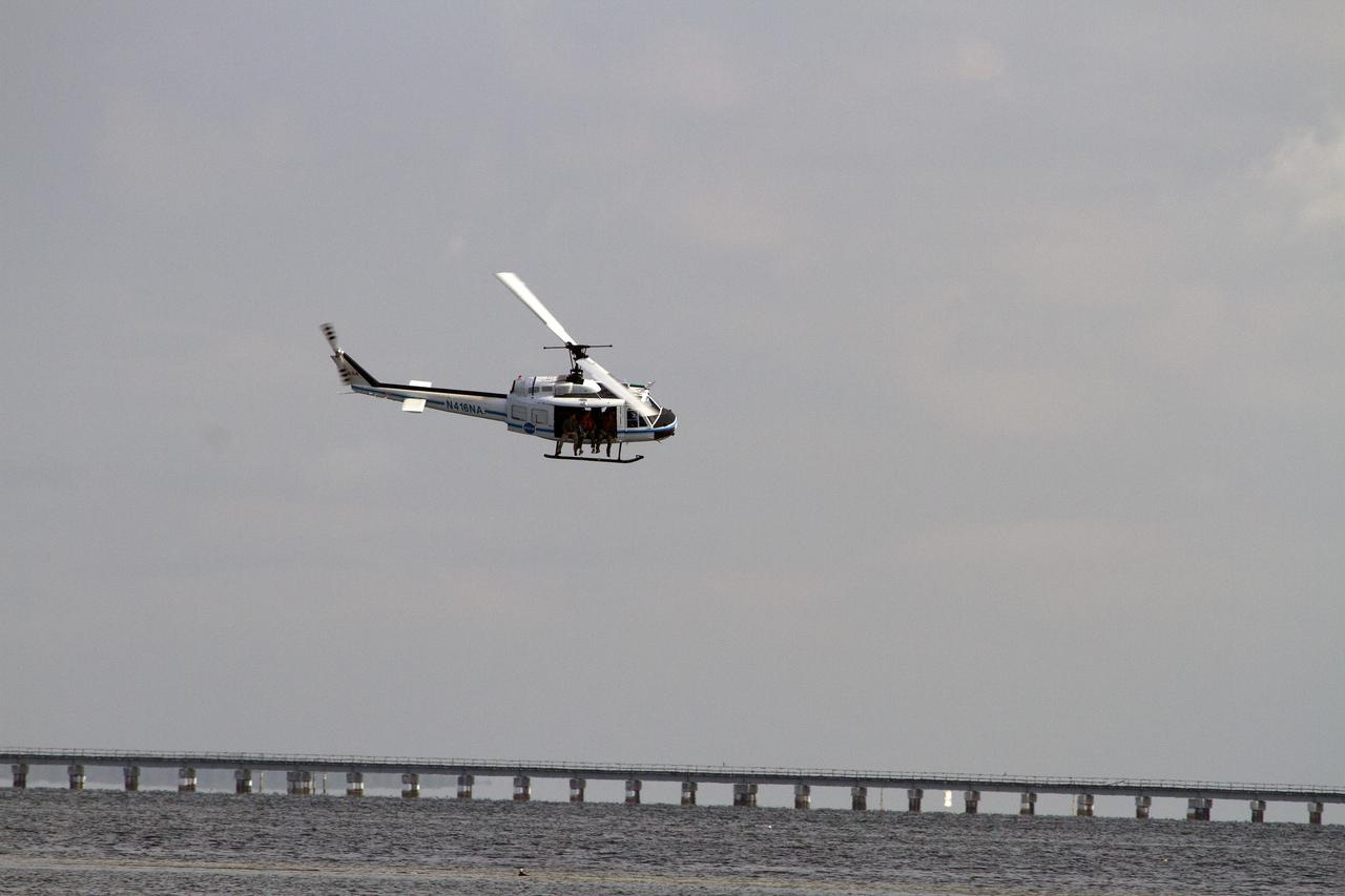 CAPE CANAVERAL, Fla. – A Huey helicopter from the Aircraft Operations branch at NASA's Kennedy Space Center in Florida flies over the Indian River Lagoon with a group of Emergency Response Team officers from the center's Protective Services branch during a training exercise. The training session focused on safely entering the water, something the ERT could be required to perform in certain situations at the center. Photo credit: NASA/ Dan Casper