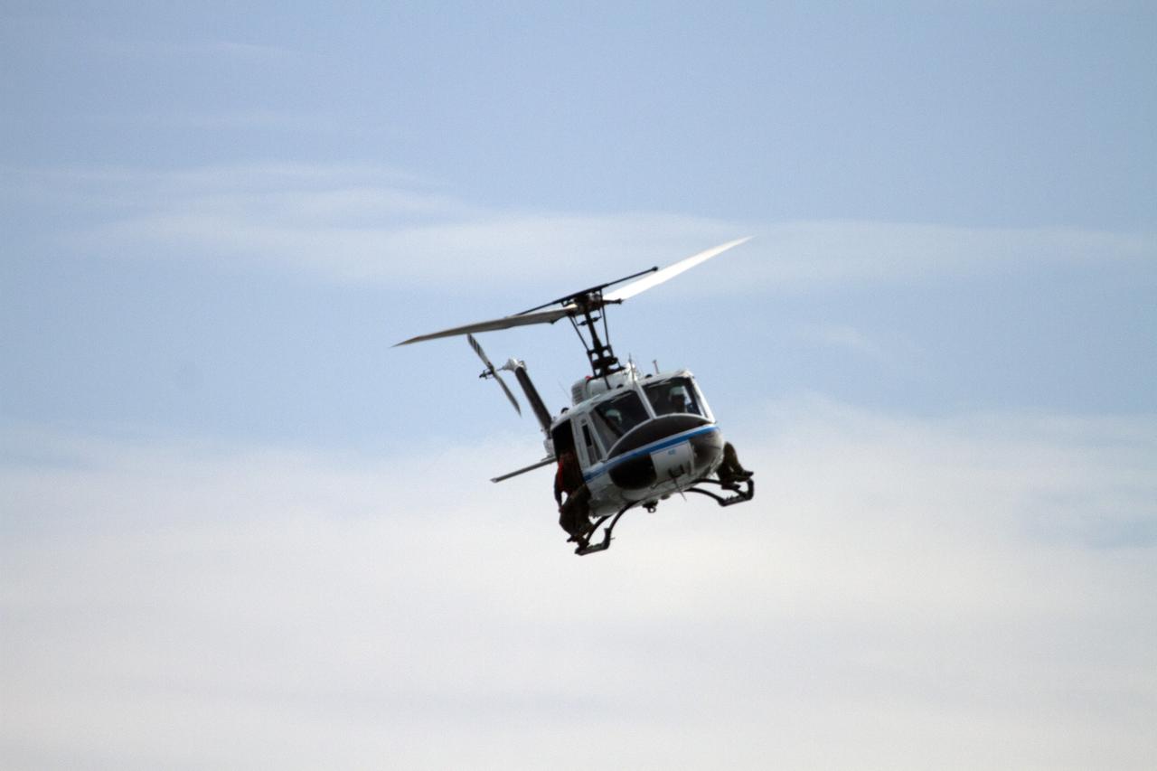 CAPE CANAVERAL, Fla. – A Huey helicopter from the Aircraft Operations branch at NASA's Kennedy Space Center in Florida flies over the Indian River Lagoon with a group of Emergency Response Team officers from the center's Protective Services branch during a training exercise. The training session focused on safely entering the water, something the ERT could be required to perform in certain situations at the center. Photo credit: NASA/ Dan Casper