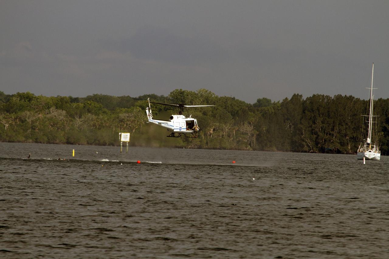 CAPE CANAVERAL, Fla. – A Huey helicopter from the Aircraft Operations branch at NASA's Kennedy Space Center in Florida hovers over the Indian River Lagoon after a group of Emergency Response Team officers from the center's Protective Services branch dropped from the helicopter during a training exercise. The training session focused on safely entering the water, something the ERT could be required to perform in certain situations at the center. Photo credit: NASA/ Dan Casper