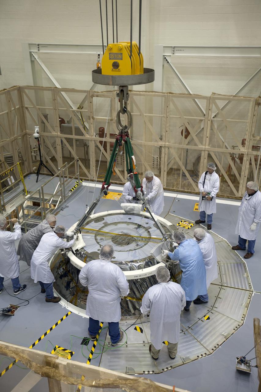 CAPE CANAVERAL, Fla. – Inside the Neil Armstrong Operations and Checkout Building high bay at NASA's Kennedy Space Center in Florida, technicians dressed in clean room suits attach a crane to the Orion crew and service module stack for Exploration Flight Test-1. Orion will be lifted out of the test cell and transferred to a mating device.     Orion is the exploration spacecraft designed to carry astronauts to destinations not yet explored by humans, including an asteroid and Mars. It will have emergency abort capability, sustain the crew during space travel and provide safe re-entry from deep space return velocities. The first unpiloted test flight of the Orion is scheduled to launch later this year atop a Delta IV Heavy rocket from Cape Canaveral Air Force Station in Florida to an altitude of 3,600 miles above the Earth's surface. The two-orbit, four-hour flight test will help engineers evaluate the systems critical to crew safety including the heat shield, parachute system and launch abort system. For more information, visit http://www.nasa.gov/orion. Photo credit: NASA/Ben Smegelsky