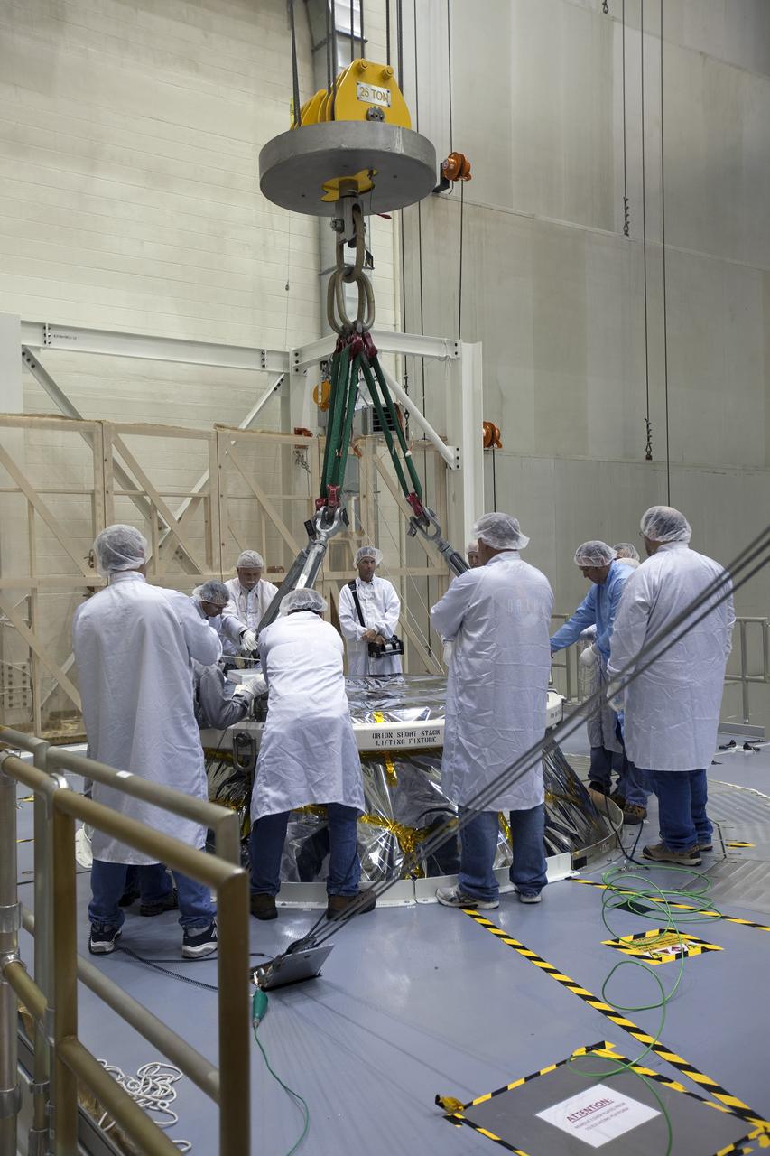 CAPE CANAVERAL, Fla. – Inside the Neil Armstrong Operations and Checkout Building high bay at NASA's Kennedy Space Center in Florida, technicians dressed in clean room suits attach a crane to the Orion crew and service module stack for Exploration Flight Test-1. Orion will be lifted out of the test cell and transferred to a mating device.    Orion is the exploration spacecraft designed to carry astronauts to destinations not yet explored by humans, including an asteroid and Mars. It will have emergency abort capability, sustain the crew during space travel and provide safe re-entry from deep space return velocities. The first unpiloted test flight of the Orion is scheduled to launch later this year atop a Delta IV Heavy rocket from Cape Canaveral Air Force Station in Florida to an altitude of 3,600 miles above the Earth's surface. The two-orbit, four-hour flight test will help engineers evaluate the systems critical to crew safety including the heat shield, parachute system and launch abort system. For more information, visit http://www.nasa.gov/orion. Photo credit: NASA/Ben Smegelsky