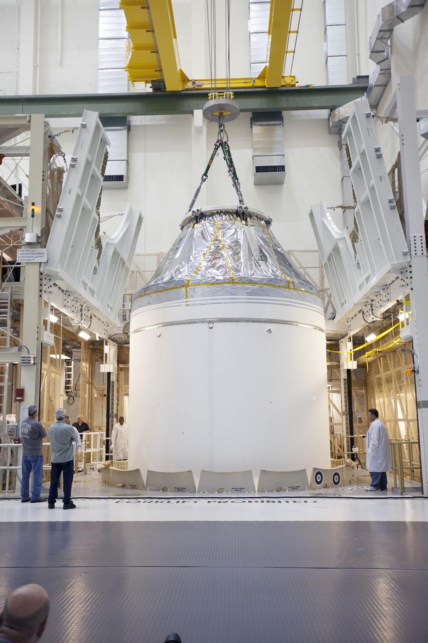 CAPE CANAVERAL, Fla. – Inside the Neil Armstrong Operations and Checkout Building high bay at NASA's Kennedy Space Center in Florida, a crane slowly lifts the Orion crew and service module stack for Exploration Flight Test-1 out of the test cell. Orion will be transferred to a mating device.    Orion is the exploration spacecraft designed to carry astronauts to destinations not yet explored by humans, including an asteroid and Mars. It will have emergency abort capability, sustain the crew during space travel and provide safe re-entry from deep space return velocities. The first unpiloted test flight of the Orion is scheduled to launch later this year atop a Delta IV Heavy rocket from Cape Canaveral Air Force Station in Florida to an altitude of 3,600 miles above the Earth's surface. The two-orbit, four-hour flight test will help engineers evaluate the systems critical to crew safety including the heat shield, parachute system and launch abort system. For more information, visit http://www.nasa.gov/orion. Photo credit: NASA/Ben Smegelsky