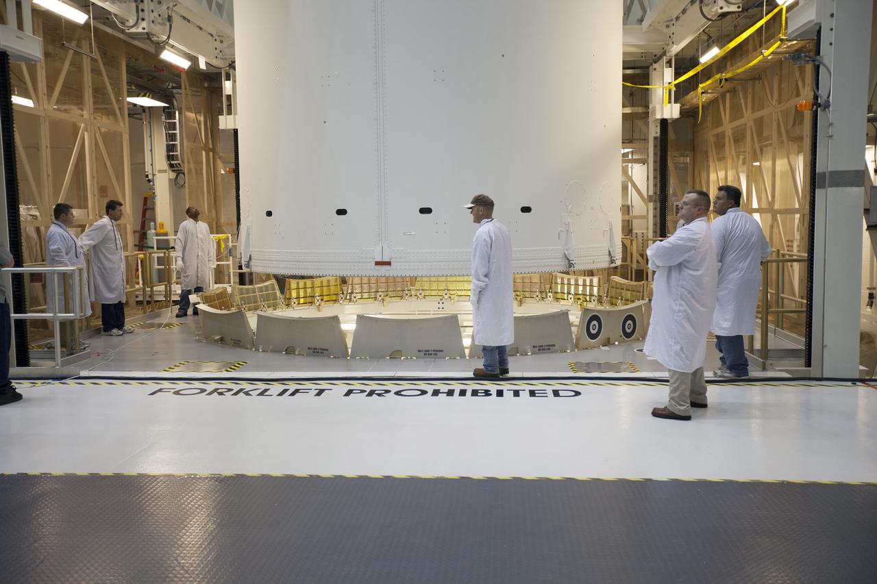 CAPE CANAVERAL, Fla. – Inside the Neil Armstrong Operations and Checkout Building high bay at NASA's Kennedy Space Center in Florida, technicians monitor the progress as a crane slowly lifts the Orion crew and service module stack for Exploration Flight Test-1 out of the test cell. Orion will be transferred to a mating device.    Orion is the exploration spacecraft designed to carry astronauts to destinations not yet explored by humans, including an asteroid and Mars. It will have emergency abort capability, sustain the crew during space travel and provide safe re-entry from deep space return velocities. The first unpiloted test flight of the Orion is scheduled to launch later this year atop a Delta IV Heavy rocket from Cape Canaveral Air Force Station in Florida to an altitude of 3,600 miles above the Earth's surface. The two-orbit, four-hour flight test will help engineers evaluate the systems critical to crew safety including the heat shield, parachute system and launch abort system. For more information, visit http://www.nasa.gov/orion. Photo credit: NASA/Ben Smegelsky