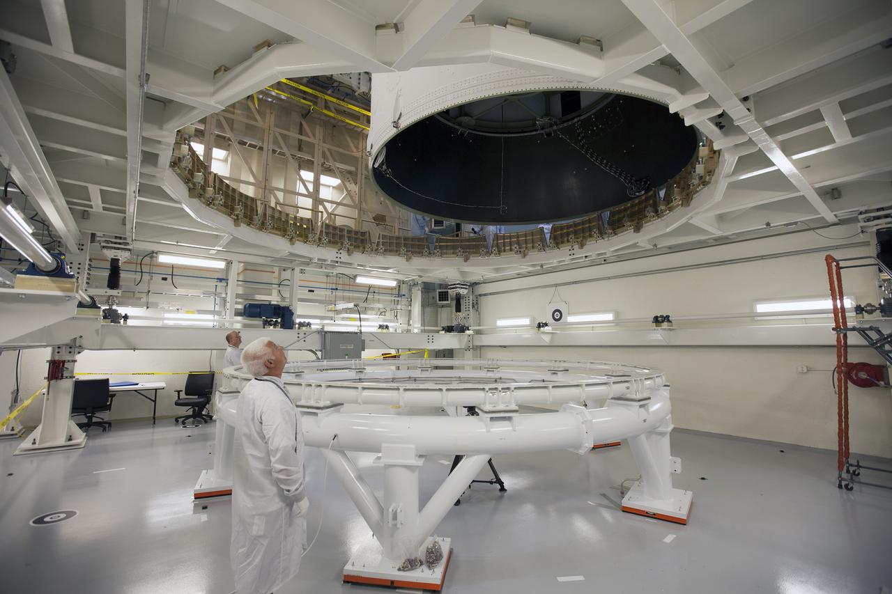 CAPE CANAVERAL, Fla. – Inside the Neil Armstrong Operations and Checkout Building high bay at NASA's Kennedy Space Center in Florida, technicians monitor the progress as a crane lifts the Orion crew and service module stack for Exploration Flight Test-1 out of the test cell. Orion will be transferred to a mating device.    Orion is the exploration spacecraft designed to carry astronauts to destinations not yet explored by humans, including an asteroid and Mars. It will have emergency abort capability, sustain the crew during space travel and provide safe re-entry from deep space return velocities. The first unpiloted test flight of the Orion is scheduled to launch later this year atop a Delta IV Heavy rocket from Cape Canaveral Air Force Station in Florida to an altitude of 3,600 miles above the Earth's surface. The two-orbit, four-hour flight test will help engineers evaluate the systems critical to crew safety including the heat shield, parachute system and launch abort system. For more information, visit http://www.nasa.gov/orion. Photo credit: NASA/Ben Smegelsky