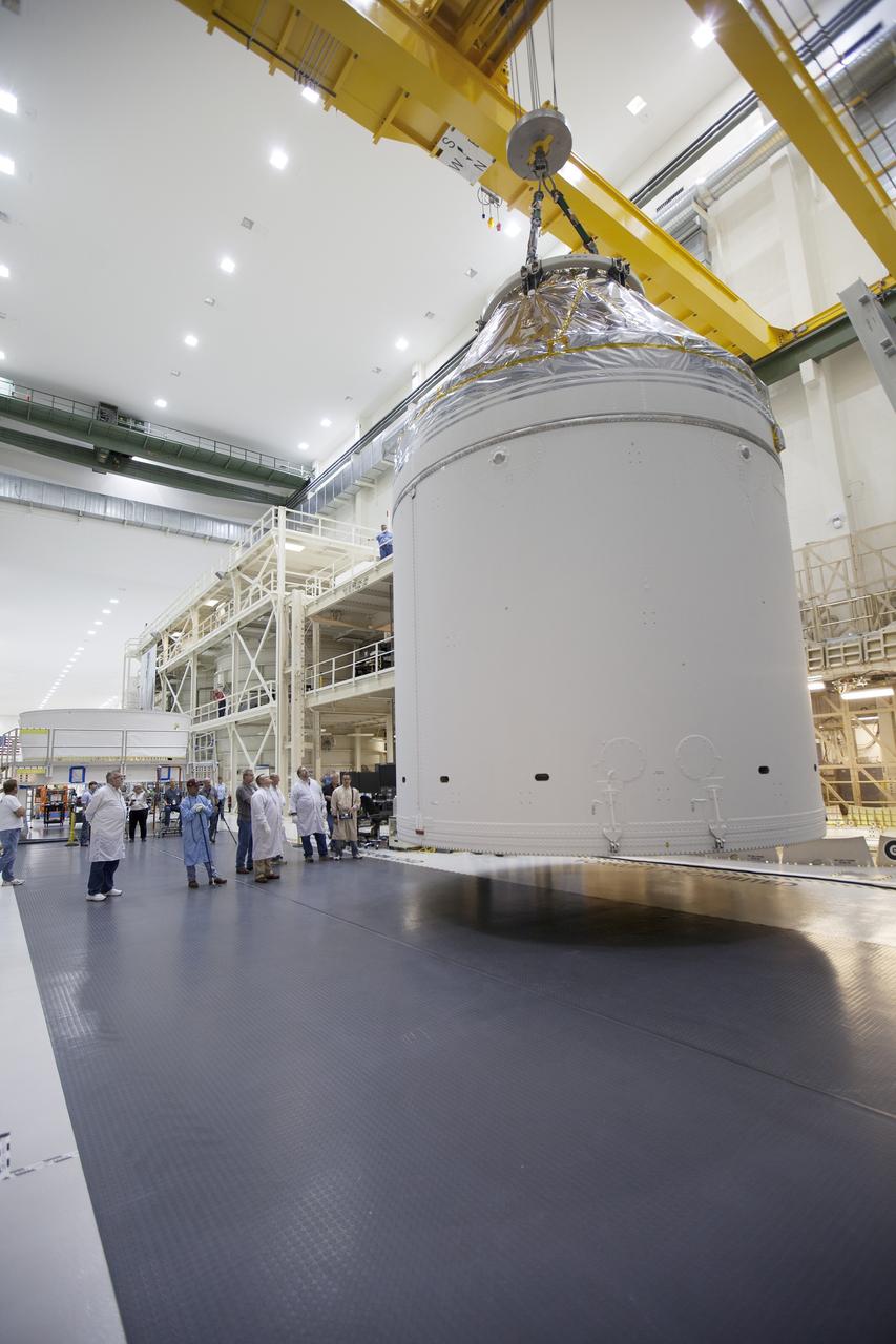 CAPE CANAVERAL, Fla. – Inside the Neil Armstrong Operations and Checkout Building high bay at NASA's Kennedy Space Center in Florida, a crane has lifted the Orion crew and service module stack for Exploration Flight Test-1 out of the test cell and is being transferred to a mating device. A protective covering surrounds the crew module.    Orion is the exploration spacecraft designed to carry astronauts to destinations not yet explored by humans, including an asteroid and Mars. It will have emergency abort capability, sustain the crew during space travel and provide safe re-entry from deep space return velocities. The first unpiloted test flight of the Orion is scheduled to launch later this year atop a Delta IV Heavy rocket from Cape Canaveral Air Force Station in Florida to an altitude of 3,600 miles above the Earth's surface. The two-orbit, four-hour flight test will help engineers evaluate the systems critical to crew safety including the heat shield, parachute system and launch abort system. For more information, visit http://www.nasa.gov/orion. Photo credit: NASA/Ben Smegelsky