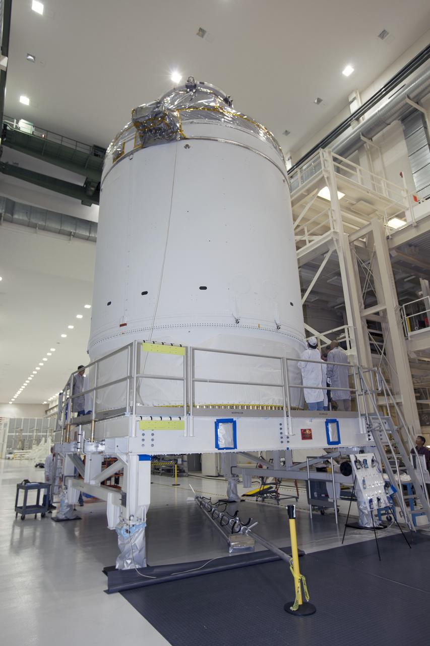 CAPE CANAVERAL, Fla. – Inside the Neil Armstrong Operations and Checkout Building high bay at NASA's Kennedy Space Center in Florida, the Orion crew and service module stack for Exploration Flight Test-1 was lifted by crane out of the test cell. The stack has been lowered onto the mating device. Technicians are attaching the stack to the mating device. A protective covering surrounds the crew module.      Orion is the exploration spacecraft designed to carry astronauts to destinations not yet explored by humans, including an asteroid and Mars. It will have emergency abort capability, sustain the crew during space travel and provide safe re-entry from deep space return velocities. The first unpiloted test flight of the Orion is scheduled to launch later this year atop a Delta IV Heavy rocket from Cape Canaveral Air Force Station in Florida to an altitude of 3,600 miles above the Earth's surface. The two-orbit, four-hour flight test will help engineers evaluate the systems critical to crew safety including the heat shield, parachute system and launch abort system. For more information, visit http://www.nasa.gov/orion. Photo credit: NASA/Ben Smegelsky