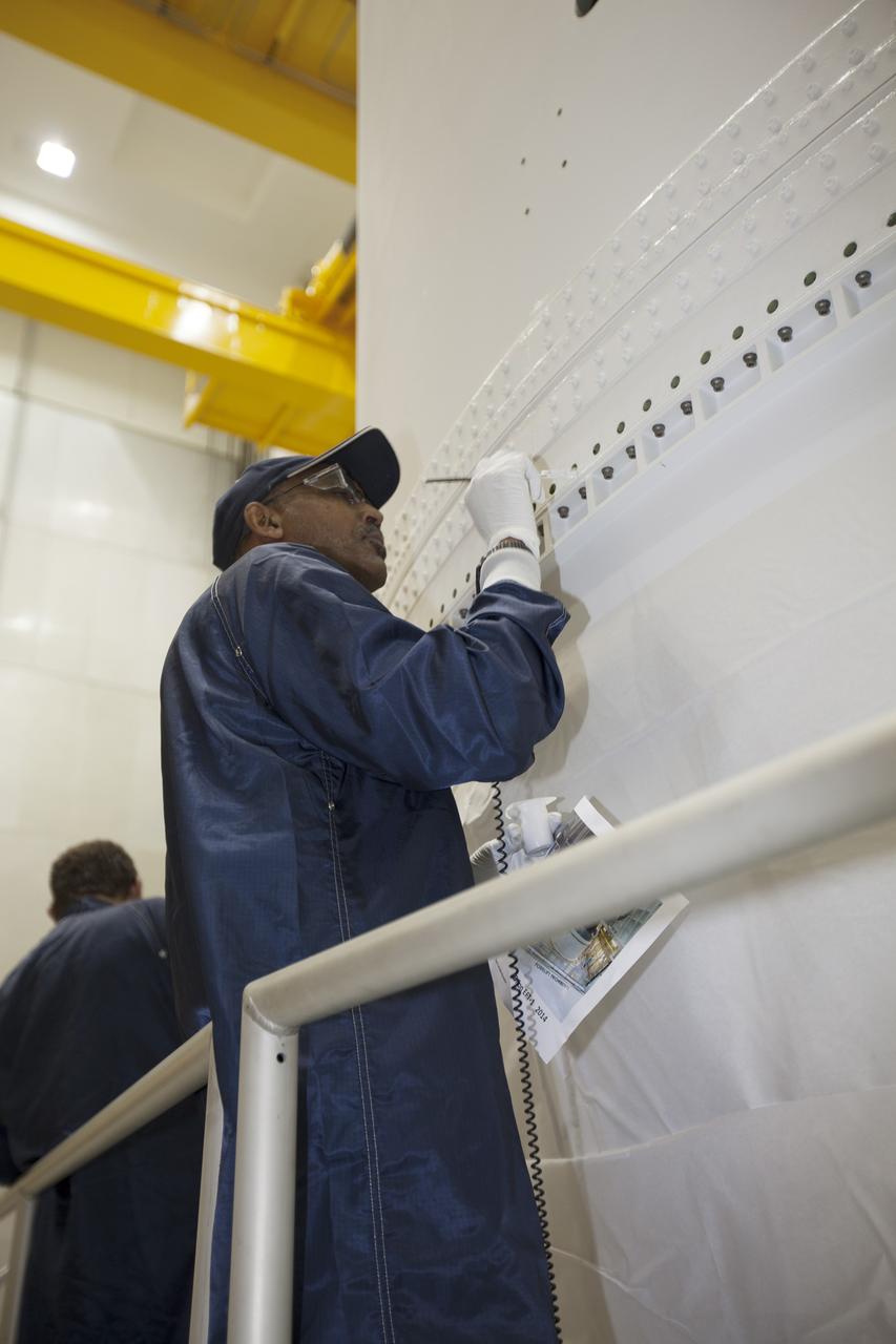 CAPE CANAVERAL, Fla. – Inside the Neil Armstrong Operations and Checkout Building high bay at NASA's Kennedy Space Center in Florida, the Orion crew and service module stack for Exploration Flight Test-1 was lifted by crane out of the test cell. The stack has been lowered onto the mating device on a stand. Technicians are attaching the stack to the mating device.      Orion is the exploration spacecraft designed to carry astronauts to destinations not yet explored by humans, including an asteroid and Mars. It will have emergency abort capability, sustain the crew during space travel and provide safe re-entry from deep space return velocities. The first unpiloted test flight of the Orion is scheduled to launch later this year atop a Delta IV Heavy rocket from Cape Canaveral Air Force Station in Florida to an altitude of 3,600 miles above the Earth's surface. The two-orbit, four-hour flight test will help engineers evaluate the systems critical to crew safety including the heat shield, parachute system and launch abort system. For more information, visit http://www.nasa.gov/orion. Photo credit: NASA/Ben Smegelsky