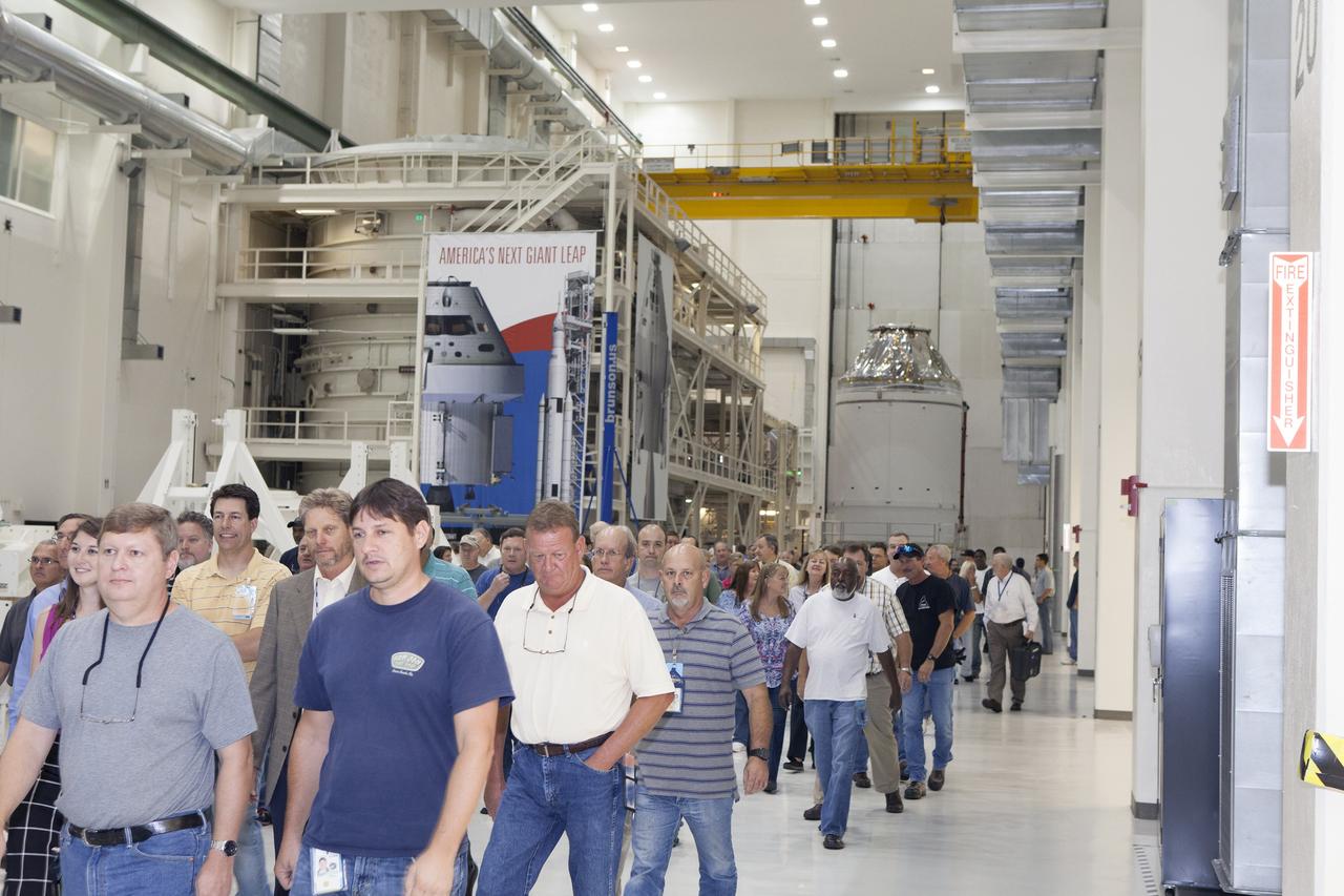 CAPE CANAVERAL, Fla. – Inside the Neil Armstrong Operations and Checkout Building high bay at NASA's Kennedy Space Center in Florida, NASA and Lockheed Martin workers leave the high bay after a ceremony to turn over the Orion spacecraft for Exploration Flight Test-1 to Lockheed Martin Ground Operations from Orion Assembly, Integration and Production. In the background is the Orion crew module stacked atop its service module. The spacecraft will be transported to the Payload Hazardous Servicing Facility where it will be fueled ahead of its December flight test.     Orion is the exploration spacecraft designed to carry astronauts to destinations not yet explored by humans, including an asteroid and Mars. It will have emergency abort capability, sustain the crew during space travel and provide safe re-entry from deep space return velocities. The first unpiloted test flight of the Orion is scheduled to launch atop a United Launch Alliance Delta IV Heavy rocket from Cape Canaveral Air Force Station in Florida in December to an altitude of 3,600 miles above the Earth's surface. The two-orbit, four-hour flight test will help engineers evaluate the systems critical to crew safety including the heat shield, parachute system and launch abort system. For more information, visit http://www.nasa.gov/orion. Photo credit: NASA/Daniel Casper