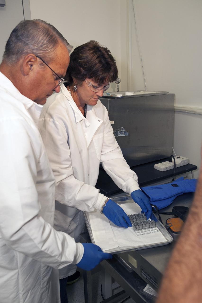 CAPE CANAVERAL, Fla. – Inside a laboratory in the Space Station Processing Facility at NASA's Kennedy Space Center in Florida, April Spinale, a payload integration specialist with Bionetics, and Ray Polniak, a quality assurance specialist with Dynamac, prepare vials for the Protein Crystal Growth 2 experiment for an acceptance leak test. The vials have been filled with clear water and will be put into a vacuum chamber to verify that the hardware is providing adequate containment for the liquids. Both are consultants for the Center for Advancement of Science in Space, or CASIS. The experiment is one of many that will be delivered to the International Space Station on the SpaceX-4 commercial cargo resupply mission. Kennedy's ISS Ground Processing and Research Project Office is providing the necessary laboratories, equipment, supplies and consumables for 61 principal investigators, including 17 from other countries, as they prepare their science experiments for flight. The SpaceX-4 flight is targeted to launch in September 2014. Photo credit: NASA/Dimitri Gerondidakis