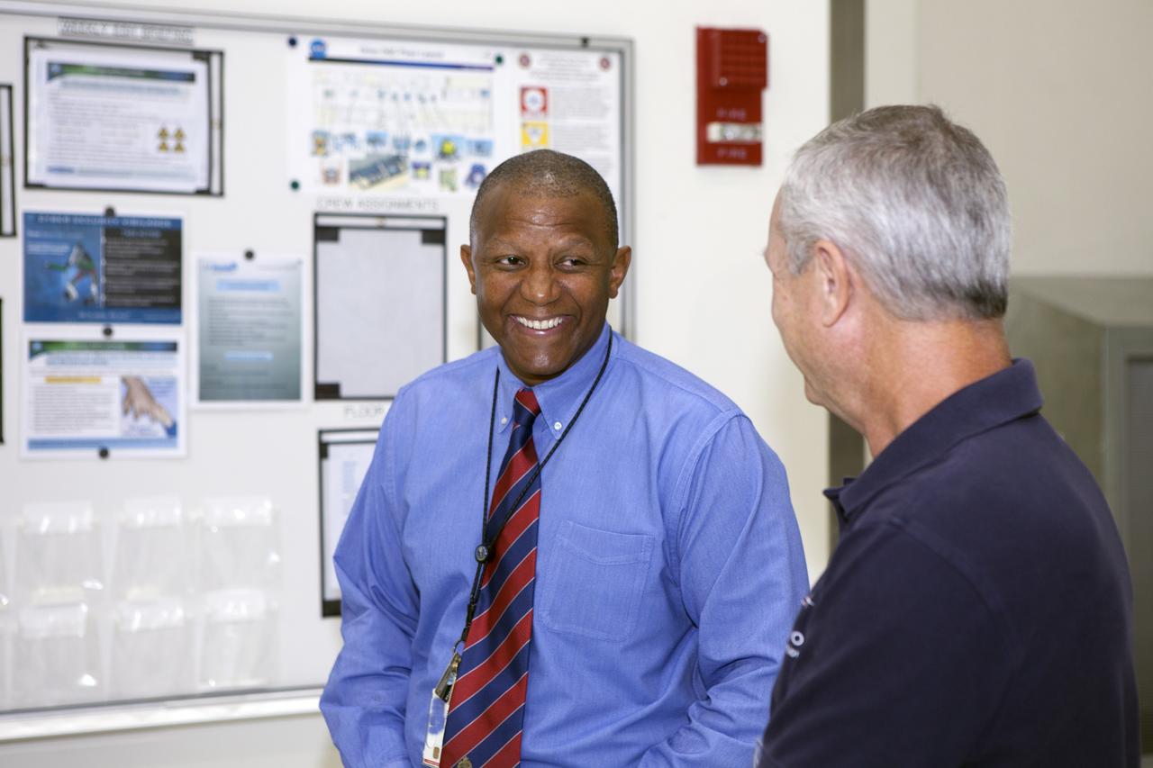 CAPE CANAVERAL, Fla. – Preparations are underway at the Neil Armstrong Operations and Checkout Building at NASA's Kennedy Space Center in Florida for the move of the Orion spacecraft for Exploration Flight Test-1 out of the high bay doors. Inside the high bay, Kennedy Associate Director Kelvin Manning, at left, talks with a worker. The spacecraft will be transported to the Payload Hazardous Servicing Facility where it will be fueled ahead of its December flight test.      Orion is the exploration spacecraft designed to carry astronauts to destinations not yet explored by humans, including an asteroid and Mars. It will have emergency abort capability, sustain the crew during space travel and provide safe re-entry from deep space return velocities. The first unpiloted test flight of the Orion is scheduled to launch atop a United Launch Alliance Delta IV Heavy rocket from Cape Canaveral Air Force Station in Florida to an altitude of 3,600 miles above the Earth's surface. The two-orbit, four-hour flight test will help engineers evaluate the systems critical to crew safety including the heat shield, parachute system and launch abort system. For more information, visit http://www.nasa.gov/orion. Photo credit: NASA/Daniel Casper