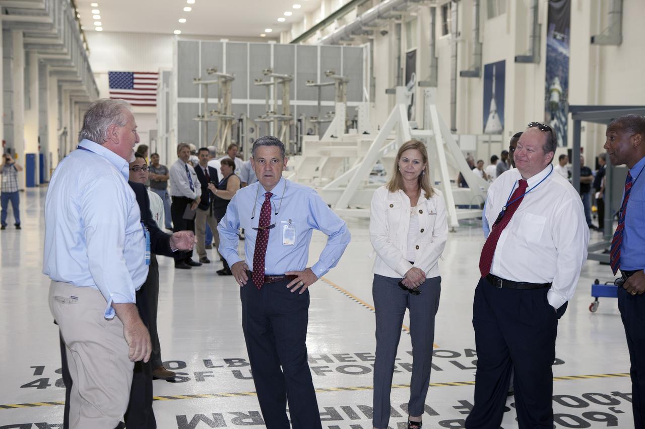 CAPE CANAVERAL, Fla. – Preparations are underway at the Neil Armstrong Operations and Checkout Building at NASA's Kennedy Space Center in Florida for the move of the Orion spacecraft for Exploration Flight Test-1 out of the high bay doors. Inside the high bay, Kennedy Center Director Bob Cabana, Deputy Center Director Janet Petro, and Burton Summerfield, NASA senior advisor for Institutional Management, talk with workers. The spacecraft will be transported to the Payload Hazardous Servicing Facility where it will be fueled ahead of its December flight test.     Orion is the exploration spacecraft designed to carry astronauts to destinations not yet explored by humans, including an asteroid and Mars. It will have emergency abort capability, sustain the crew during space travel and provide safe re-entry from deep space return velocities. The first unpiloted test flight of the Orion is scheduled to launch atop a United Launch Alliance Delta IV Heavy rocket from Cape Canaveral Air Force Station in Florida to an altitude of 3,600 miles above the Earth's surface. The two-orbit, four-hour flight test will help engineers evaluate the systems critical to crew safety including the heat shield, parachute system and launch abort system. For more information, visit http://www.nasa.gov/orion. Photo credit: NASA/Daniel Casper