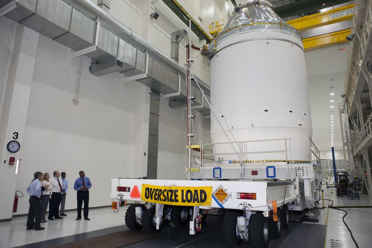 CAPE CANAVERAL, Fla. – The Orion crew module, stacked atop its service module, is being prepared for its move out of the Neil Armstrong Operations and Checkout Building high bay at NASA's Kennedy Space Center in Florida. At far left is Kennedy Center Director Bob Cabana. To Cabana's left is Kennedy Deputy Director Janet Petro, and at far right is Kennedy Associate Director Kelvin Manning. The spacecraft for Exploration Flight Test-1 will be transported to the Payload Hazardous Servicing Facility where it will be fueled ahead of its December flight test. Orion is the exploration spacecraft designed to carry astronauts to destinations not yet explored by humans, including an asteroid and Mars. It will have emergency abort capability, sustain the crew during space travel and provide safe re-entry from deep space return velocities. The first unpiloted test flight of the Orion is scheduled to launch atop a United Launch Alliance Delta IV Heavy rocket from Cape Canaveral Air Force Station in Florida to an altitude of 3,600 miles above the Earth's surface. The two-orbit, four-hour flight test will help engineers evaluate the systems critical to crew safety including the heat shield, parachute system and launch abort system. For more information, visit http://www.nasa.gov/orion. Photo credit: NASA/Daniel Casper