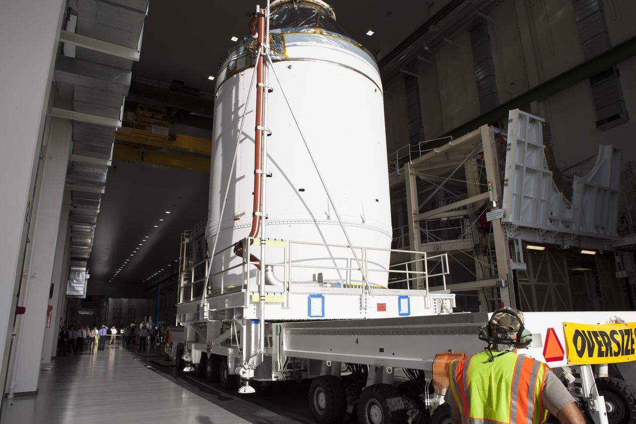 CAPE CANAVERAL, Fla. – The Orion crew module, stacked atop its service module, is moved slowly out of the Neil Armstrong Operations and Checkout Building high bay door at NASA's Kennedy Space Center in Florida. The spacecraft for Exploration Flight Test-1 will be transported to the Payload Hazardous Servicing Facility where it will be fueled ahead of its December flight test.    Orion is the exploration spacecraft designed to carry astronauts to destinations not yet explored by humans, including an asteroid and Mars. It will have emergency abort capability, sustain the crew during space travel and provide safe re-entry from deep space return velocities. The first unpiloted test flight of the Orion is scheduled to launch atop a United Launch Alliance Delta IV Heavy rocket from Cape Canaveral Air Force Station in Florida to an altitude of 3,600 miles above the Earth's surface. The two-orbit, four-hour flight test will help engineers evaluate the systems critical to crew safety including the heat shield, parachute system and launch abort system. For more information, visit http://www.nasa.gov/orion. Photo credit: NASA/Daniel Casper